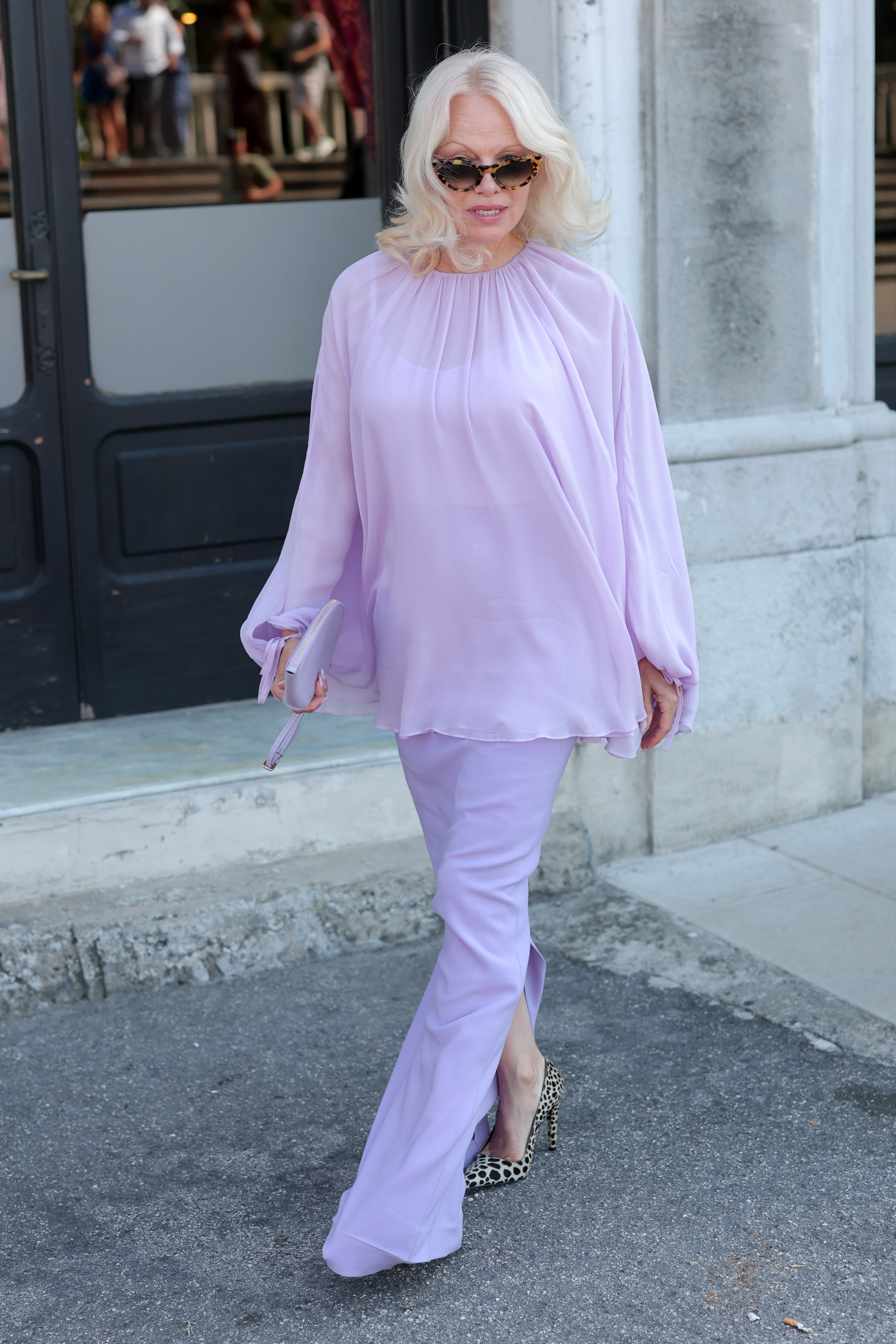 Anderson's leopard-print shoes peeked out beneath her floor-length lavender pants as she walked in Venice on September 7. The footwear became one of the most praised details of the look online, while the length and loose fit of the pants drew a more divided response. | Source: Getty Images