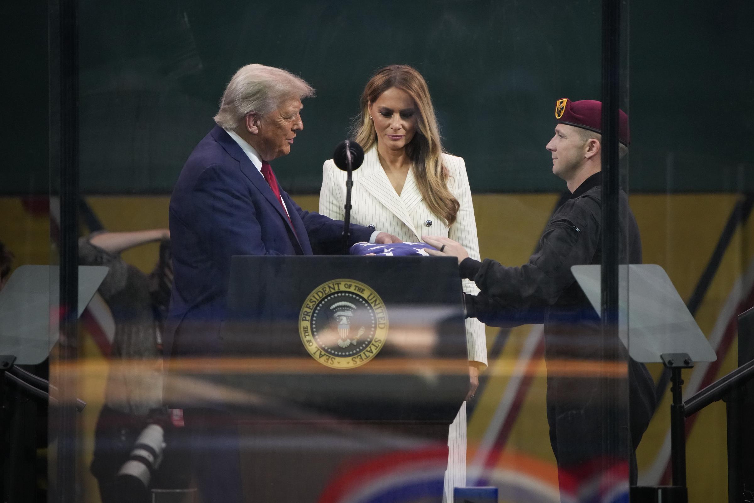 Donald and Melania Trump stand together as he is given an American flag by a member of the U.S. Army parachute team at the end of the U.S Army parade in Washington, DC, on June 14, 2025 | Source: Getty Images
