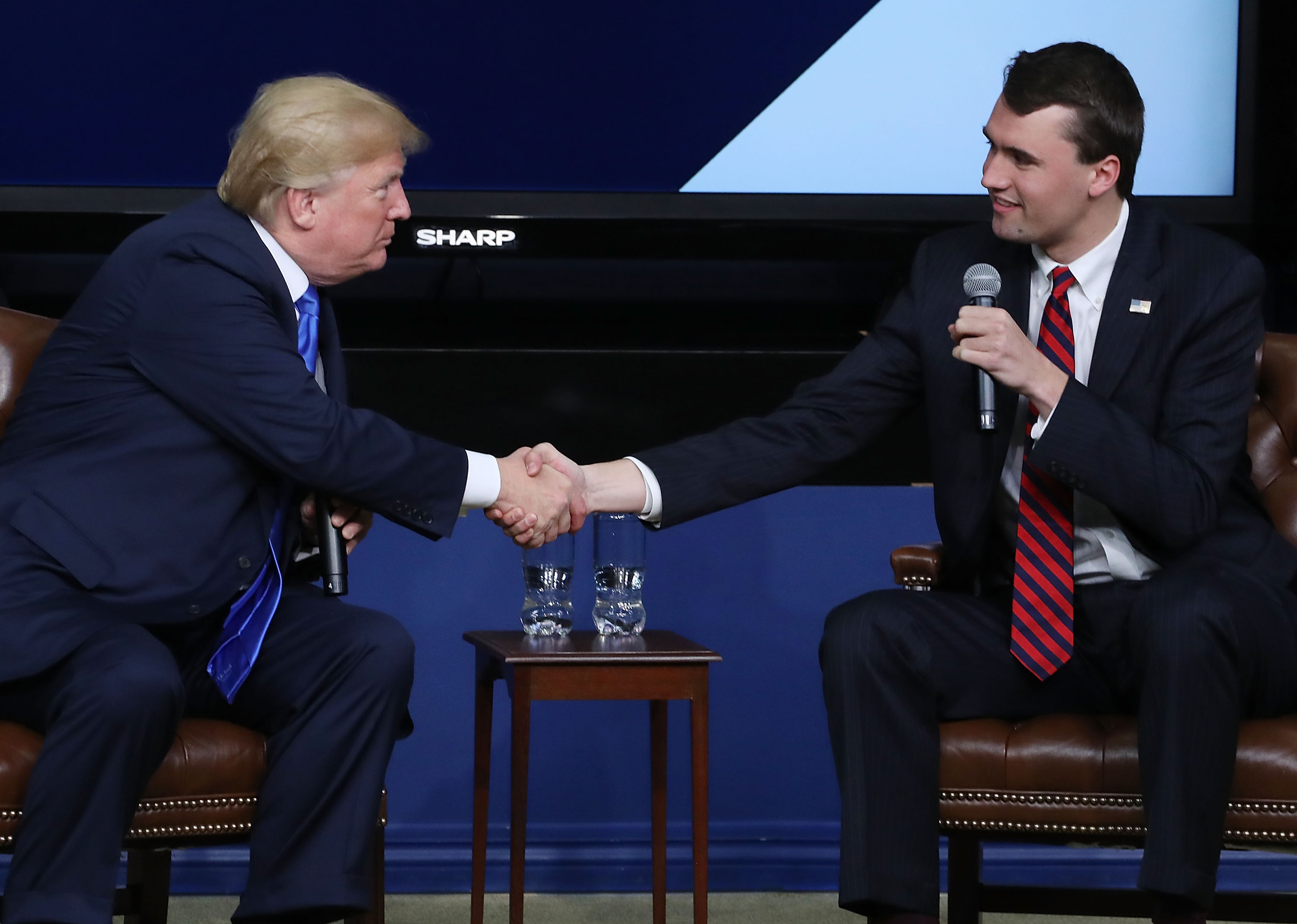 Donald Trump shakes hands with Charlie Kirk during the Generation Next Summit at the White House on March 22, 2018 | Source: Getty Images