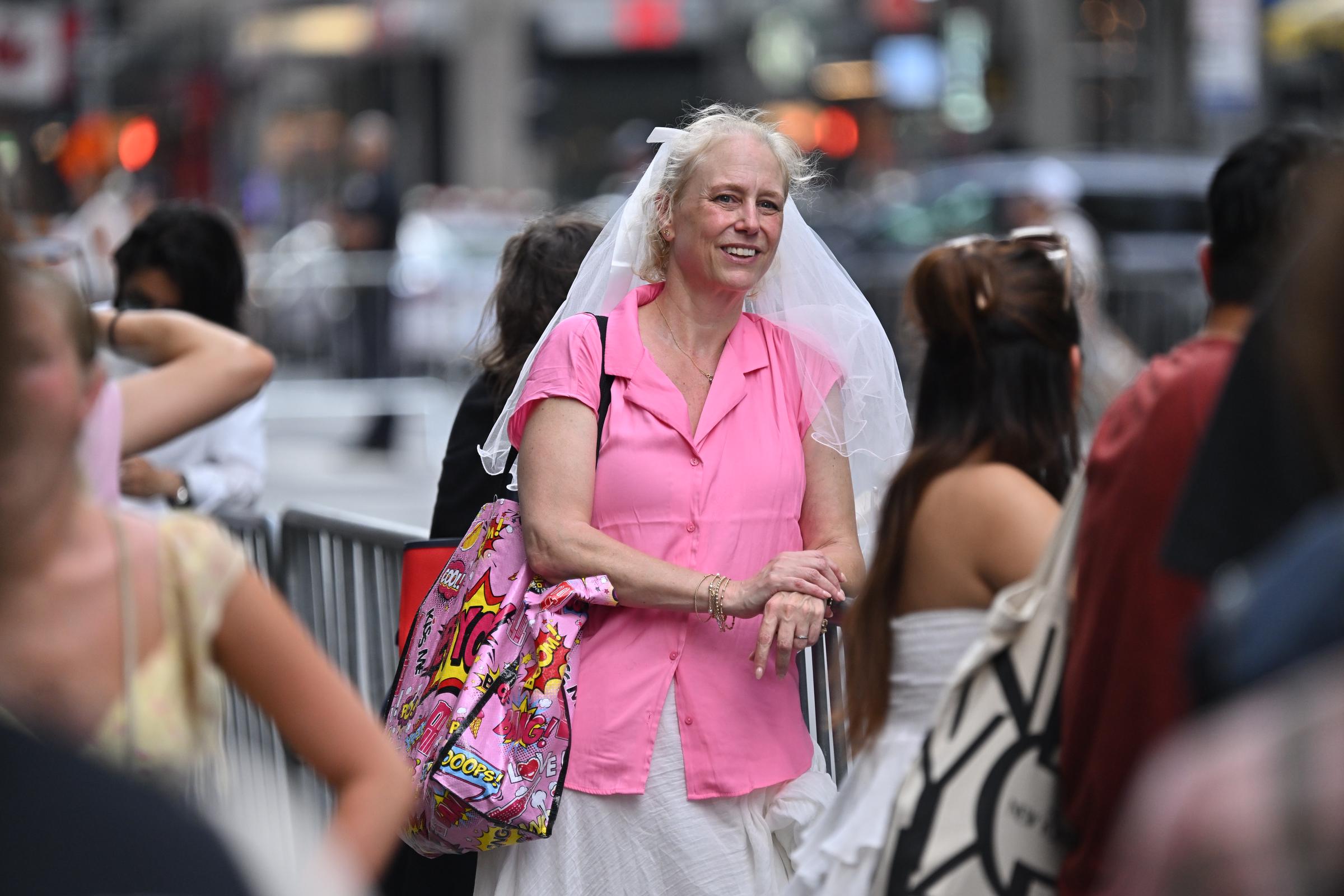 Photos inside the venue remained scarce and limited to what some celebrities posted, but a massive crowd of fans gathered outside. As seen in this photo, one stood outside Madison Square Garden wearing a veil. | Source: Getty Images