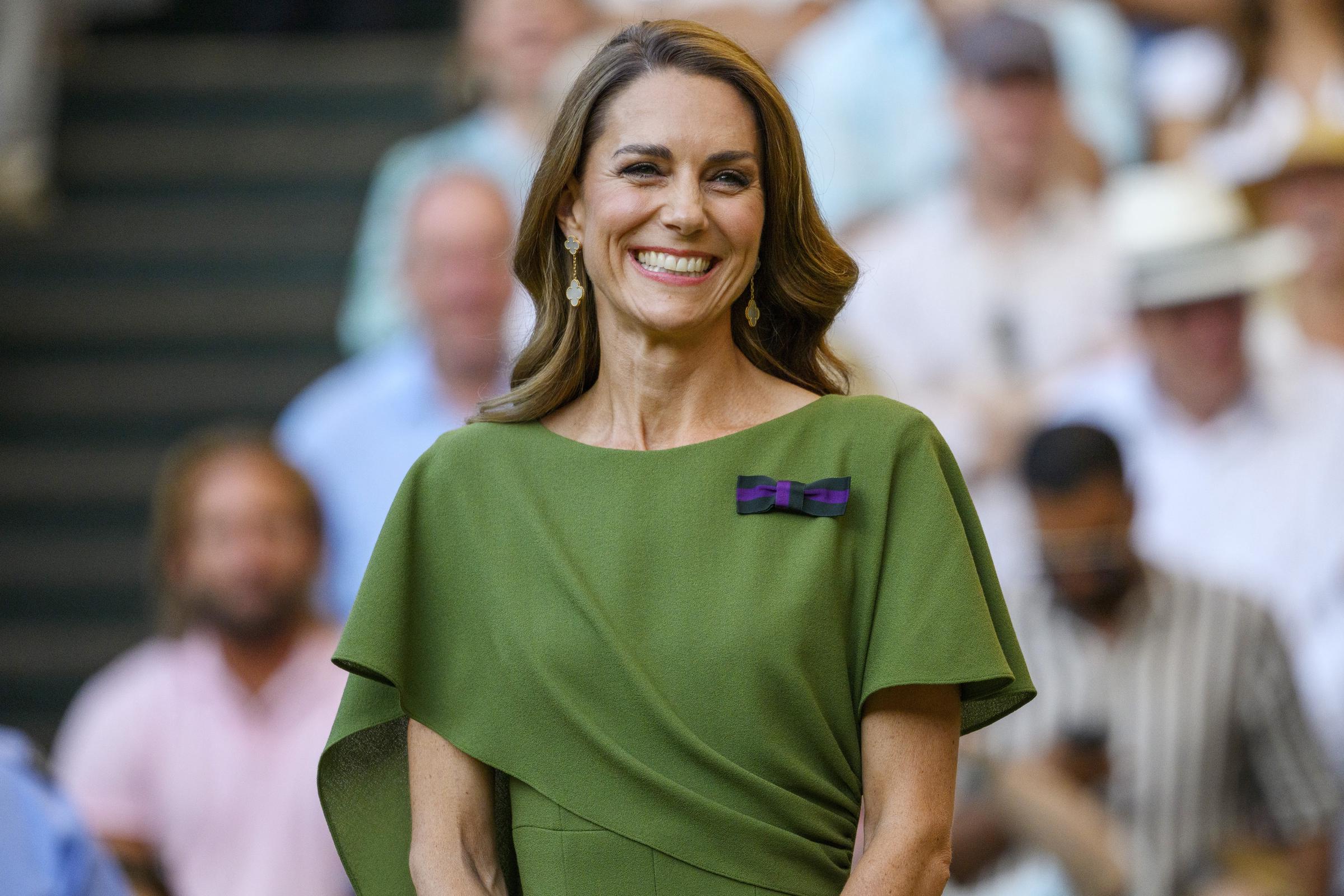 A closer look at Catherine's final Wimbledon outfit shows the custom olive-green Emilia Wickstead dress she chose for the men's singles final. She completed the look with soft waves, drop earrings, and a warm smile as she prepared for the trophy presentation. | Source: Getty Images
