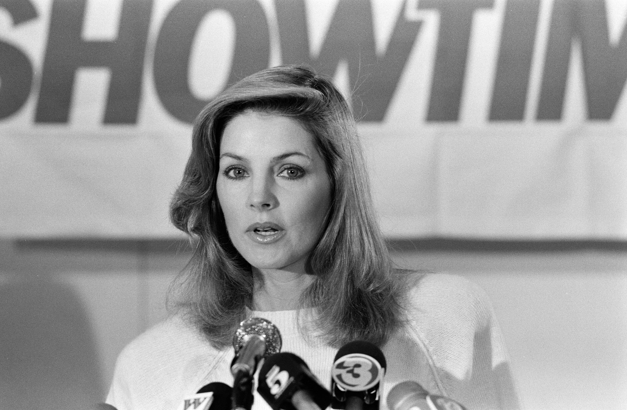 Priscilla Presley, Chairwoman of Elvis Presley Enterprises, addresses reporters at a press conference to promote an Elvis Presley Showtime television special in Memphis, Tennessee, on January 4, 1985, wearing a light crew-neck knit sweater and styling her layered shoulder-length hair with a soft side sweep. | Source: Getty Images