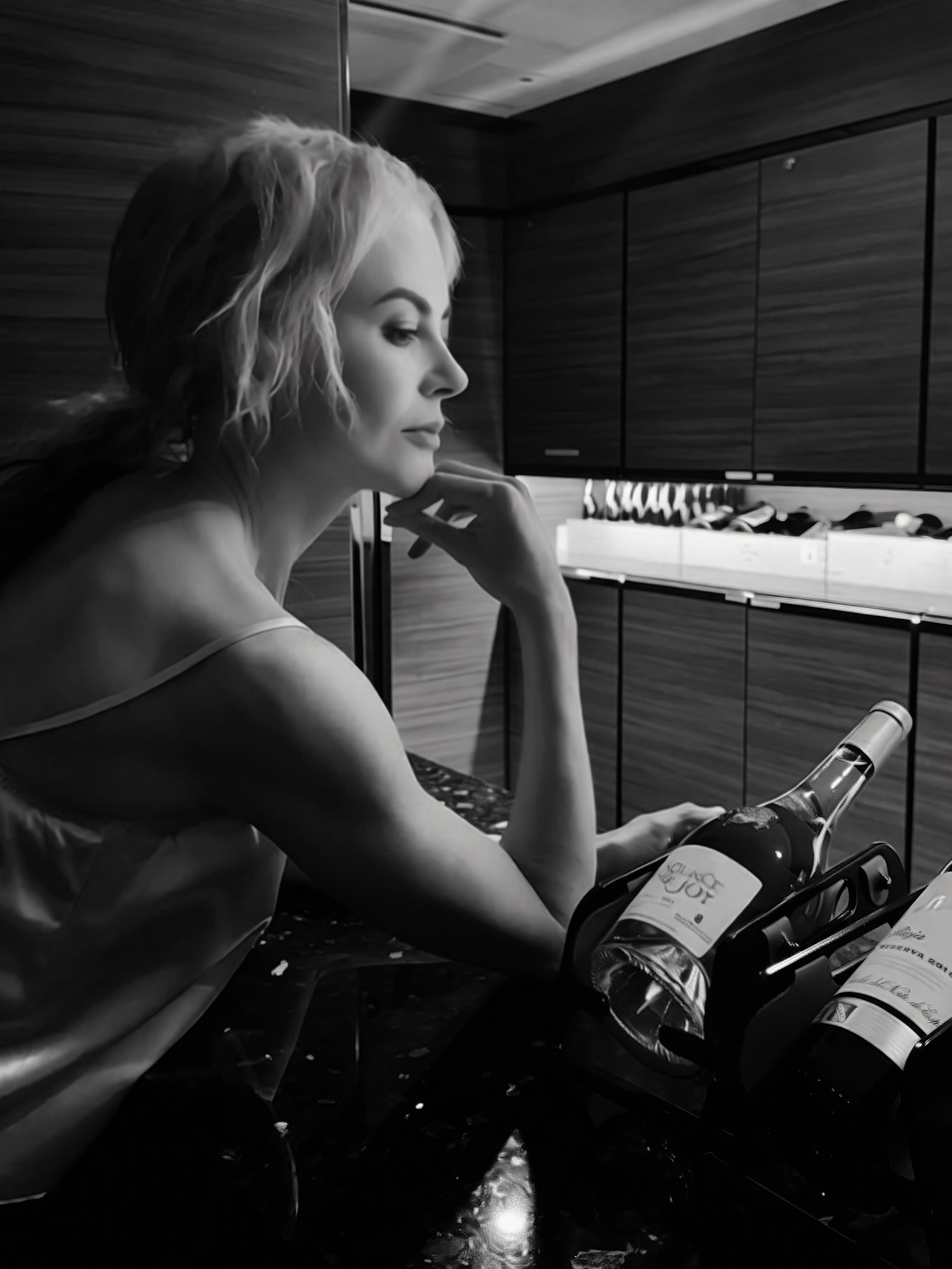 Kidman serves pure moody elegance in a atmospheric black-and-white portrait taken inside the ship's bar. Resting her chin on her hand in a delicate silk tank, she posed alongside fine wine bottles. | Source: Instagram/nicolekidman
