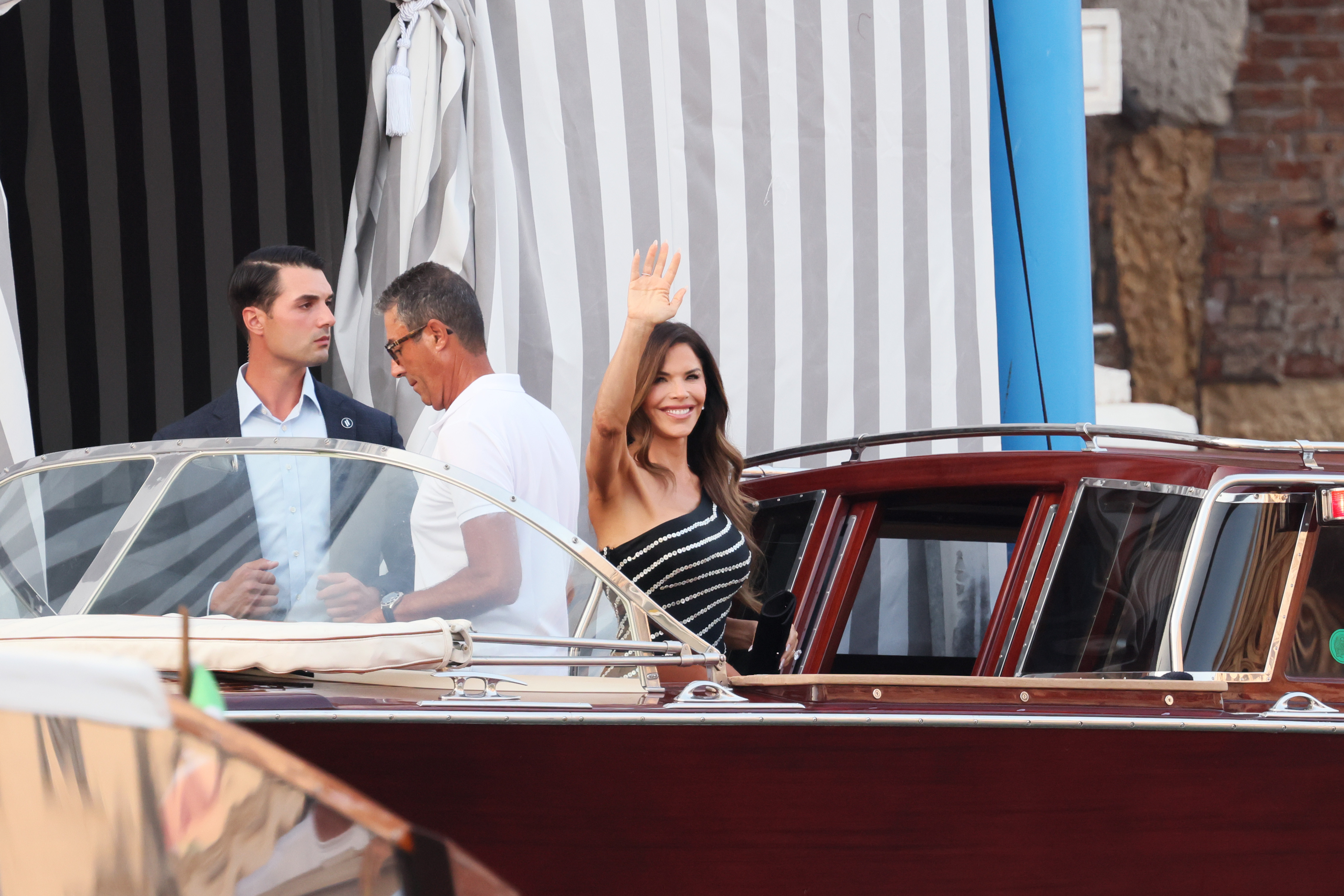 Lauren Sanchez smiles and waves as she prepares to board a boat outside the couple’s hotel in Venice, Italy on June 25, 2025 | Source: Getty Images