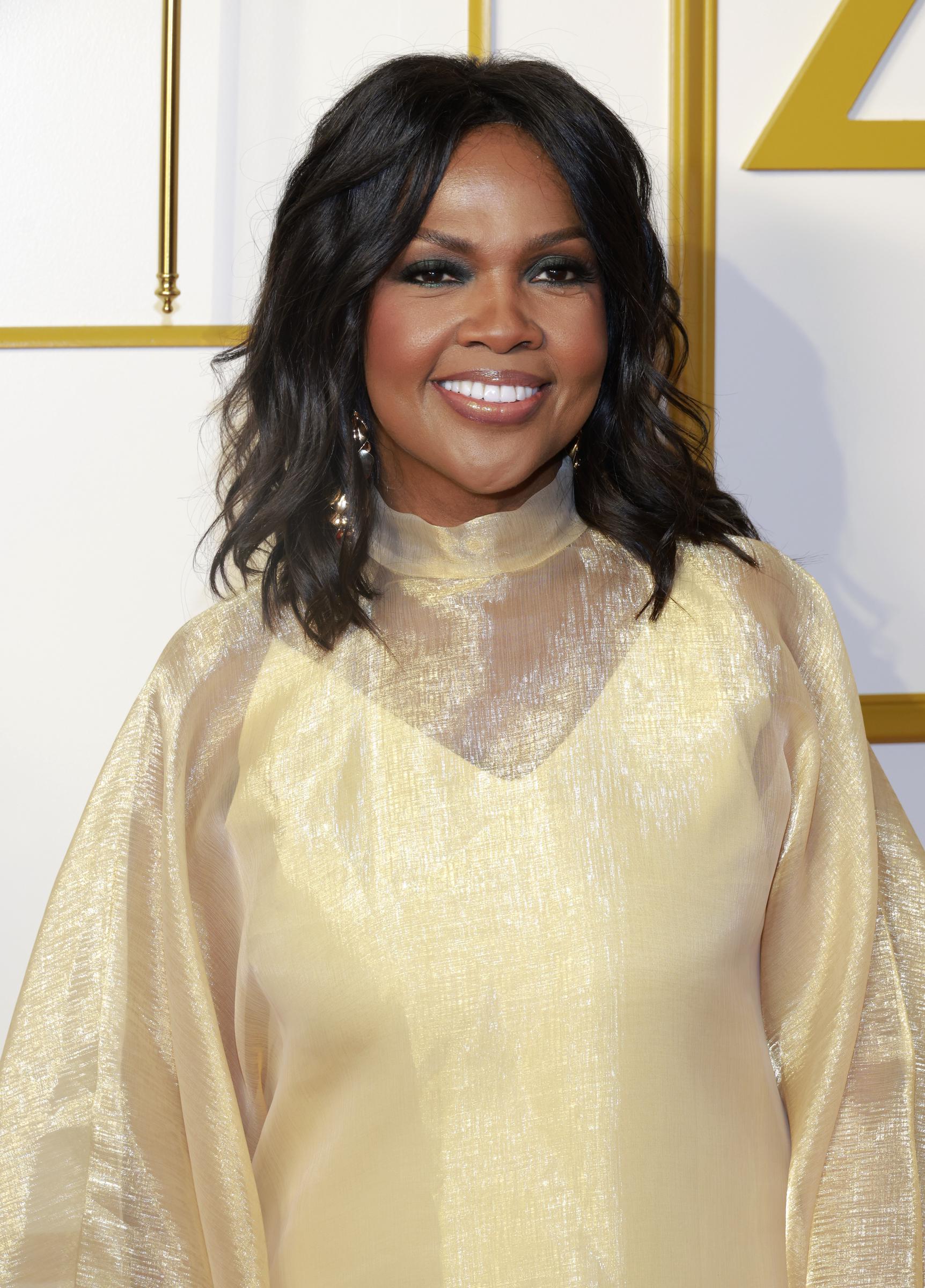 CeCe Winans smiles at the camera while attending the 40th Annual Stellar Gospel Music Awards in Nashville, Tennessee, on August 16, 2025, wearing a flowing gold gown.