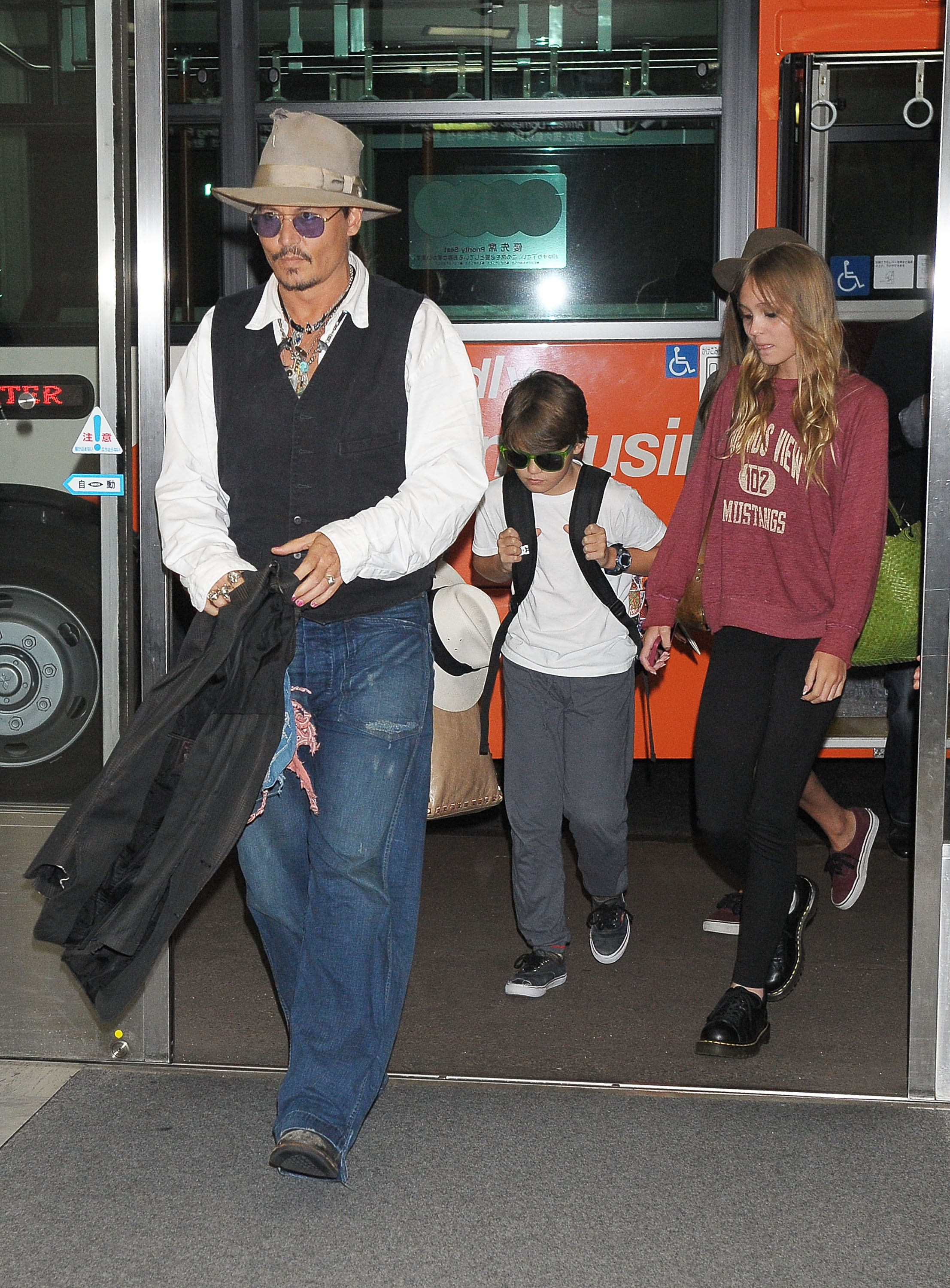 Johnny Depp walks through Narita International Airport in Japan with his children, Jack Depp and Lily-Rose Depp, on July 16, 2013 | Source: Getty Images