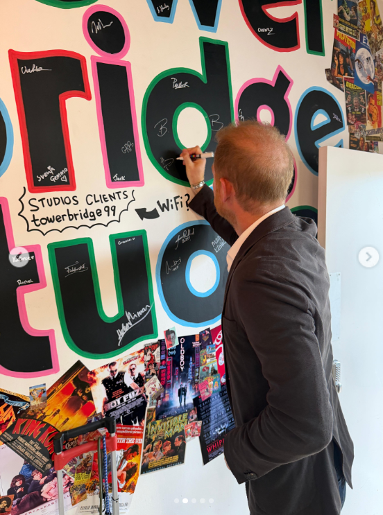 Prince Harry adds his name to Tower Bridge Studios' colorful celebrity wall during his September 4 visit. The London studio later shared the moment on Instagram after hosting him for the day. | Source: Instagram/towerbridgestudios