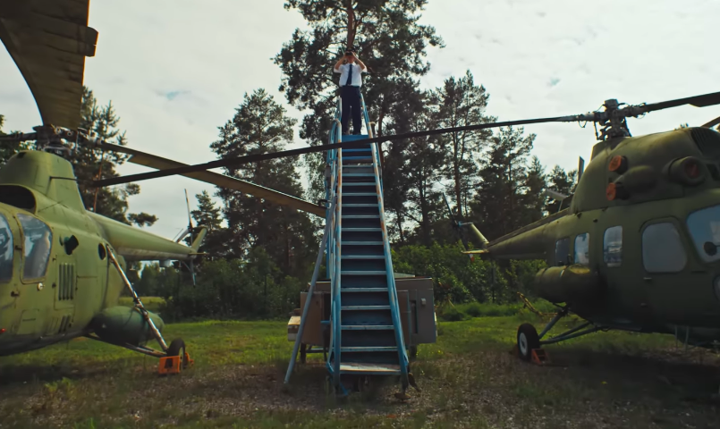 One scene from "Flowers" has drawn particular attention because Tree appears between two helicopters. Fans have since called the moment "eerie," pointing to it as a detail that feels impossible to ignore in hindsight. | Source: YouTube/Oliver Tree