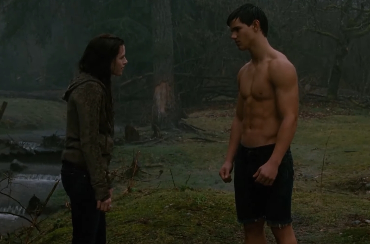 Taylor Lautner appeared shirtless as Jacob Black while speaking with another character during a scene set outdoors. | Source: YouTube/Clip Queens