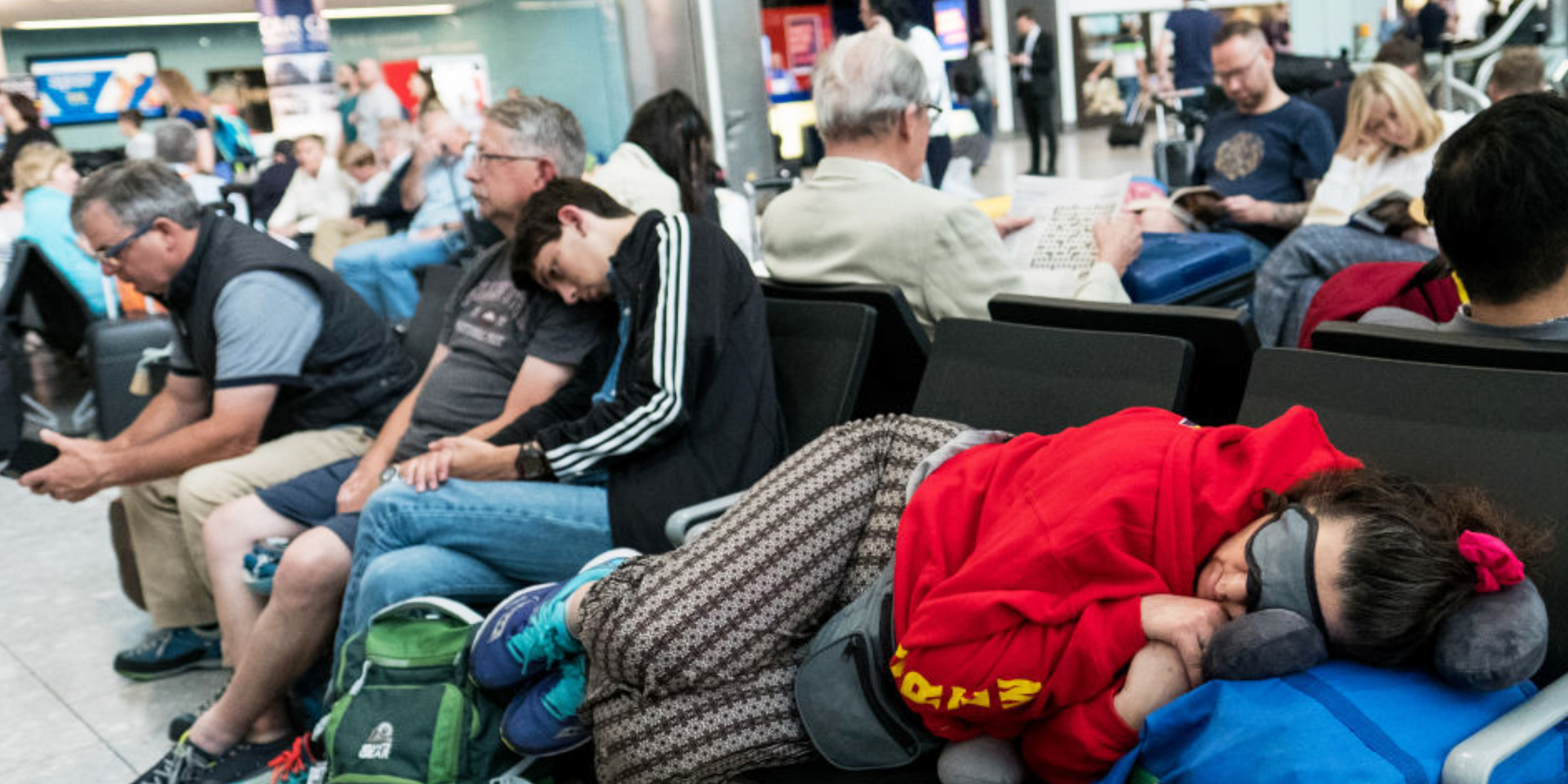 Travelers rest at a busy international airport | Source: Getty Images