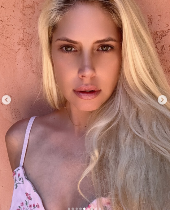 Warm terracotta tones set the scene for Cleo Rose Elliott in a sun-drenched portrait uploaded to Instagram on November 13, 2024. Posing close to the camera with a soft, natural expression, she donned a delicate pink floral strap top and let her voluminous platinum blonde locks cascade freely over one shoulder, accented by a subtle gold chain necklace.