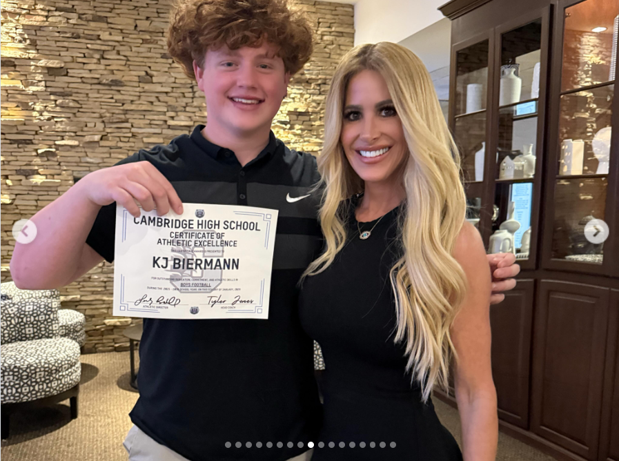 Kim Zolciak and her son KJ Biermann pose together as he holds a certificate of athletic excellence from Cambridge High School. The photo was shared by Kim weeks before news of his arrest, when she publicly celebrated her son as “her heart walking outside of her body” and praised his dedication to football. | Source: Instagram/kimzolciakbiermann