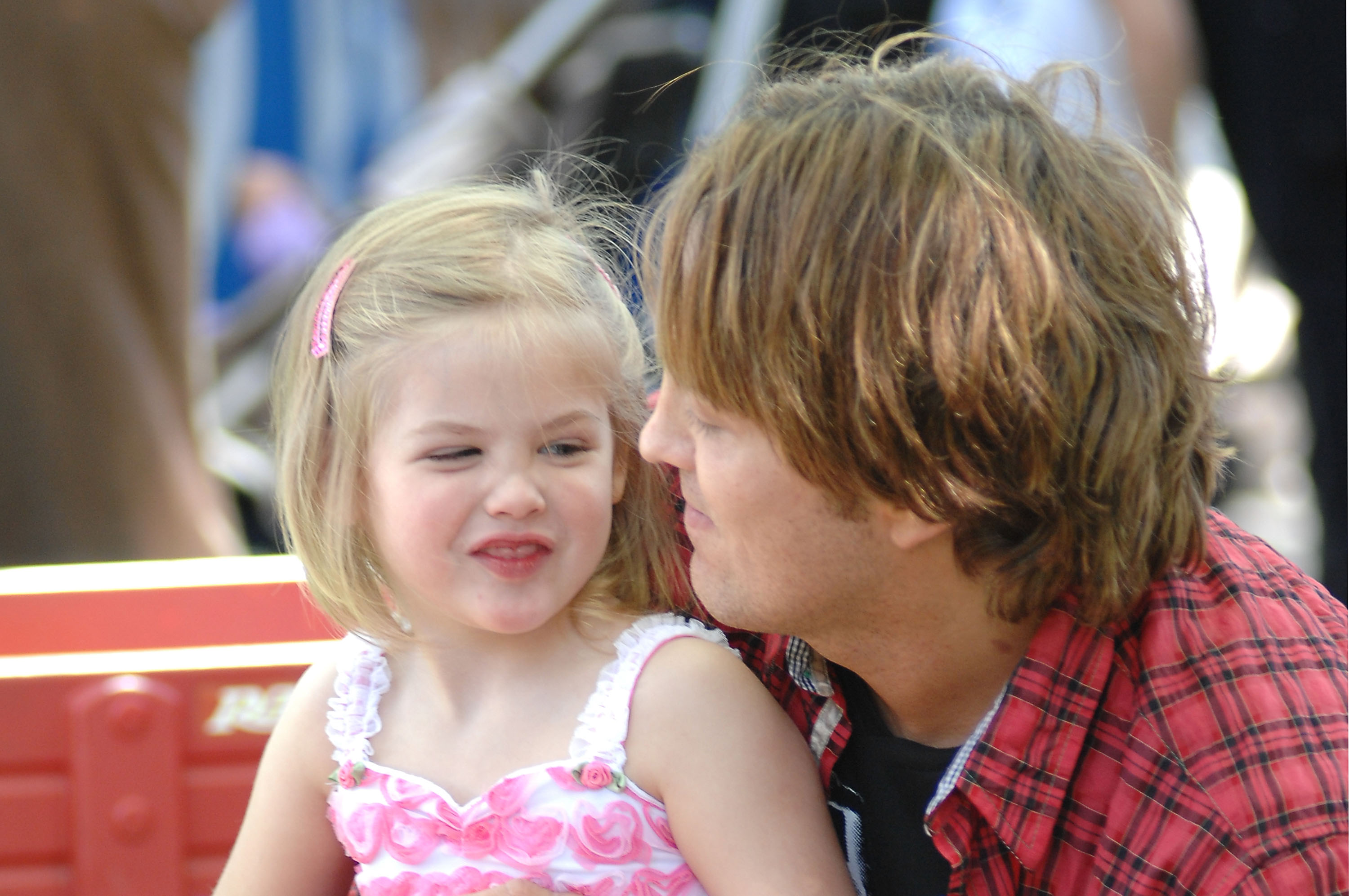 Sporting a cheeky, playful expression and a sweet pink barrette swept through her sunny blonde bob, 3-year-old Dannielynn Birkhead looked radiant in a frilled pink-and-white sundress on February 14, 2010. Bathed in California sunshine as her father Larry leaned in close, the toddler showed off her fun-loving nature and growing comfort in front of the lens.