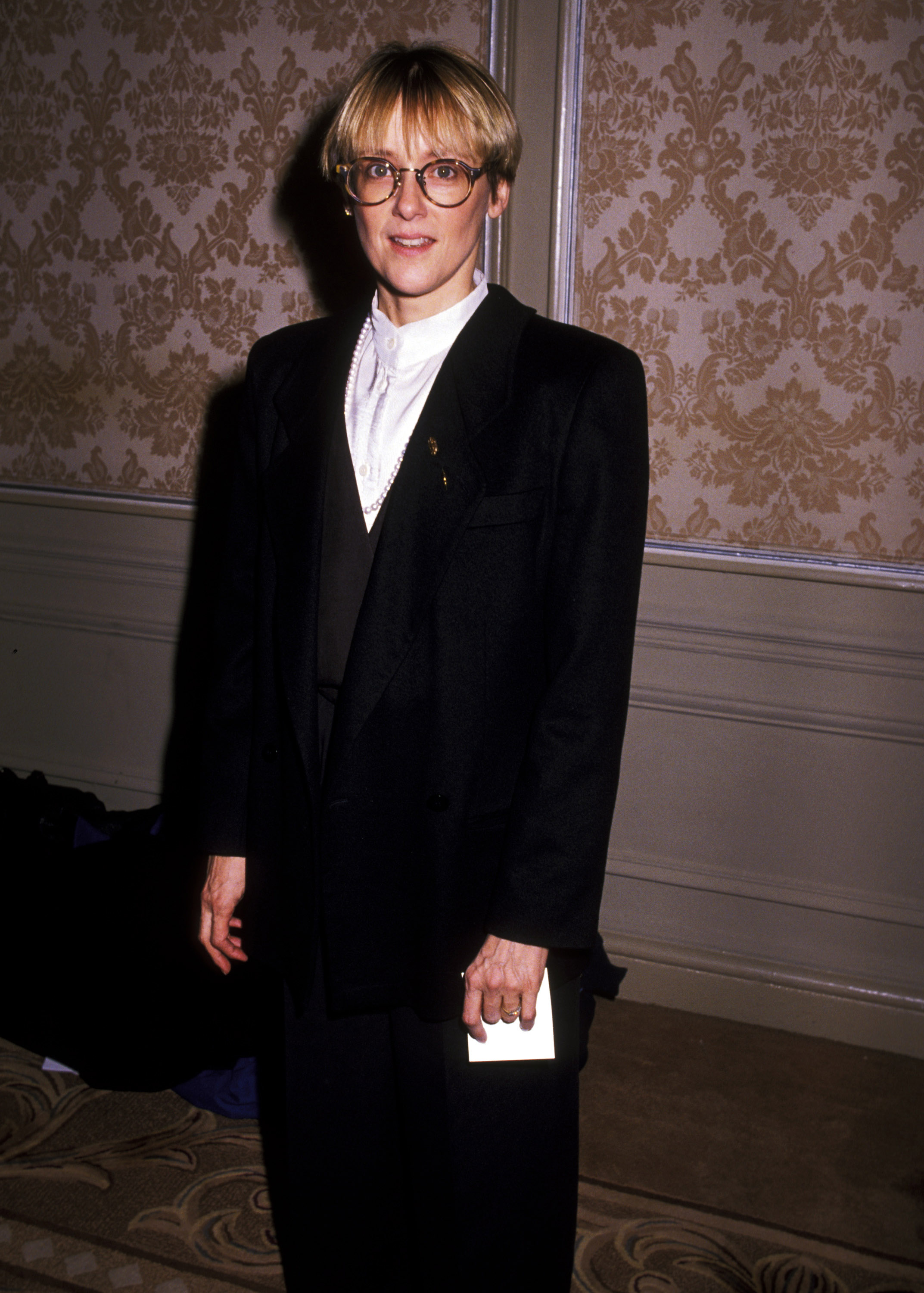 Mary Beth Hurt poses at the NY Women in Film Awards in 1989 wearing an oversized dark suit, white blouse, and round glasses. Her tailored look reflected the understated sophistication she often brought to public appearances.