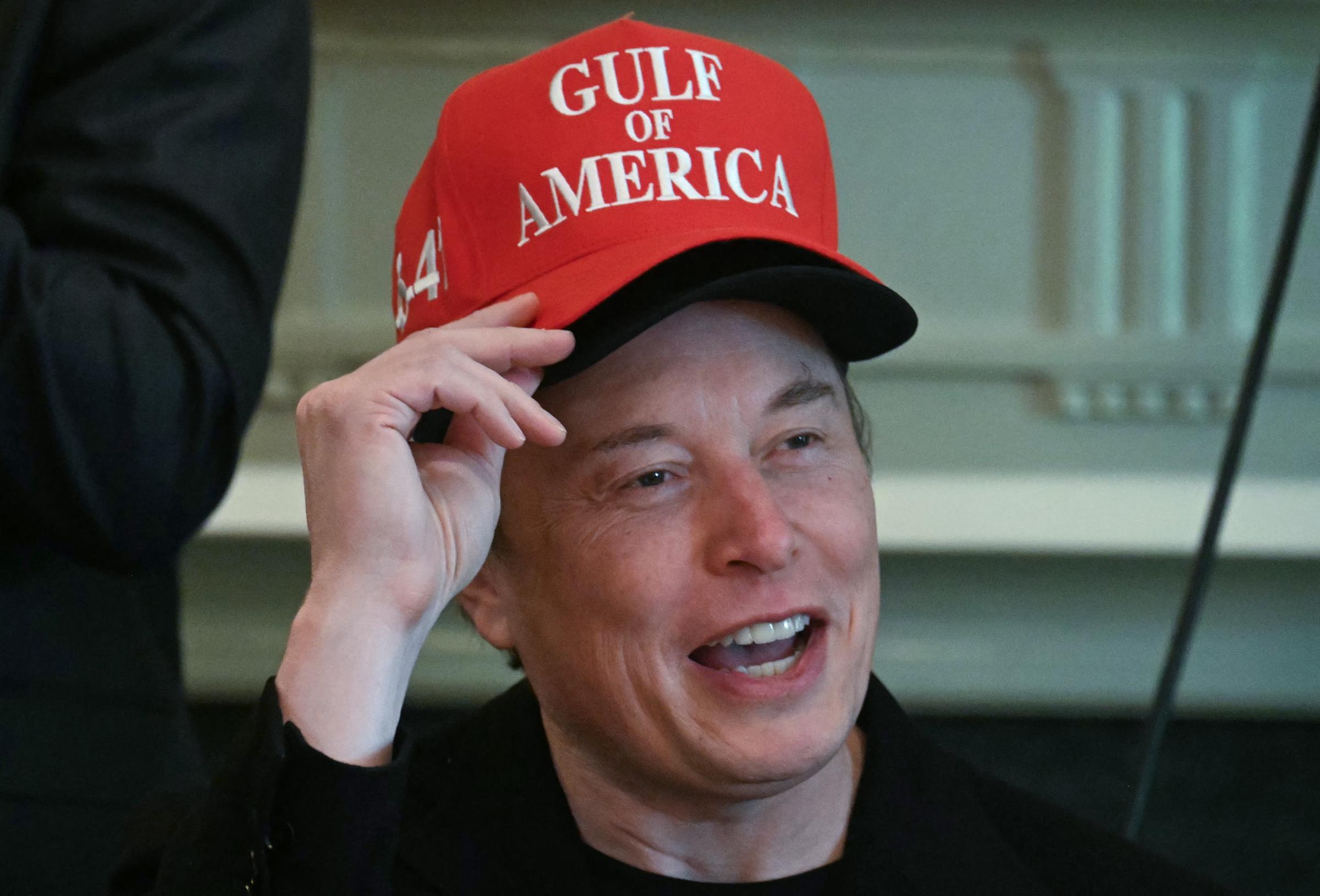 Elon Musk wearing two hats while speaking during a cabinet meeting | Source: Getty Images