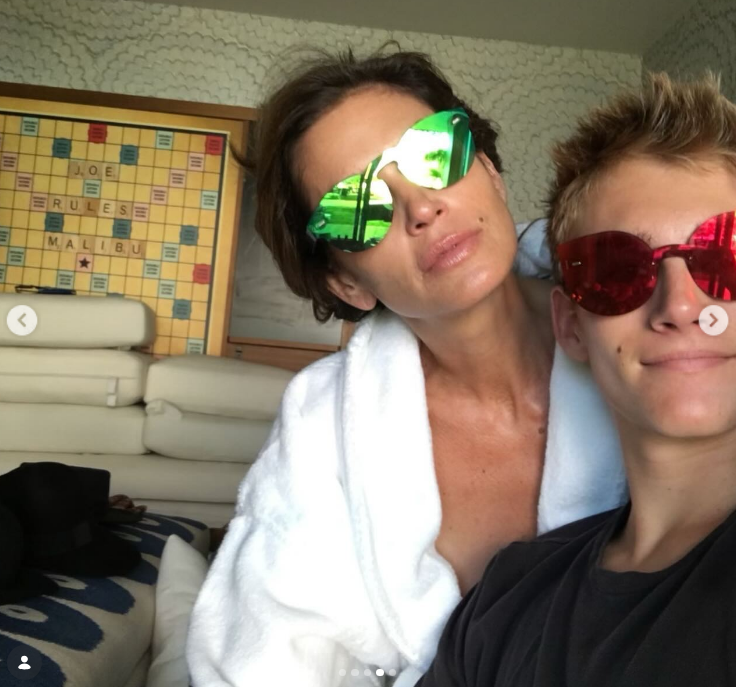 Presley Gerber leaned in for a playful throwback selfie with mom Cindy Crawford, shared in a birthday tribute post on February 20, 2024, showing Crawford in a plush white bathrobe and green mirrored sunglasses while her son wore bright red tinted shades. | Source: Instagram/presleygerber