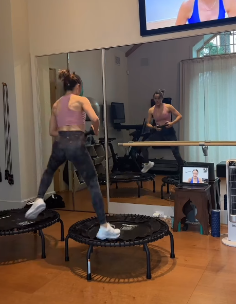 A mirrored wall reflects Jennifer Garner's movements while a tablet nearby appears to show a trainer leading the workout. | Source: Instagram/jennifer.garner