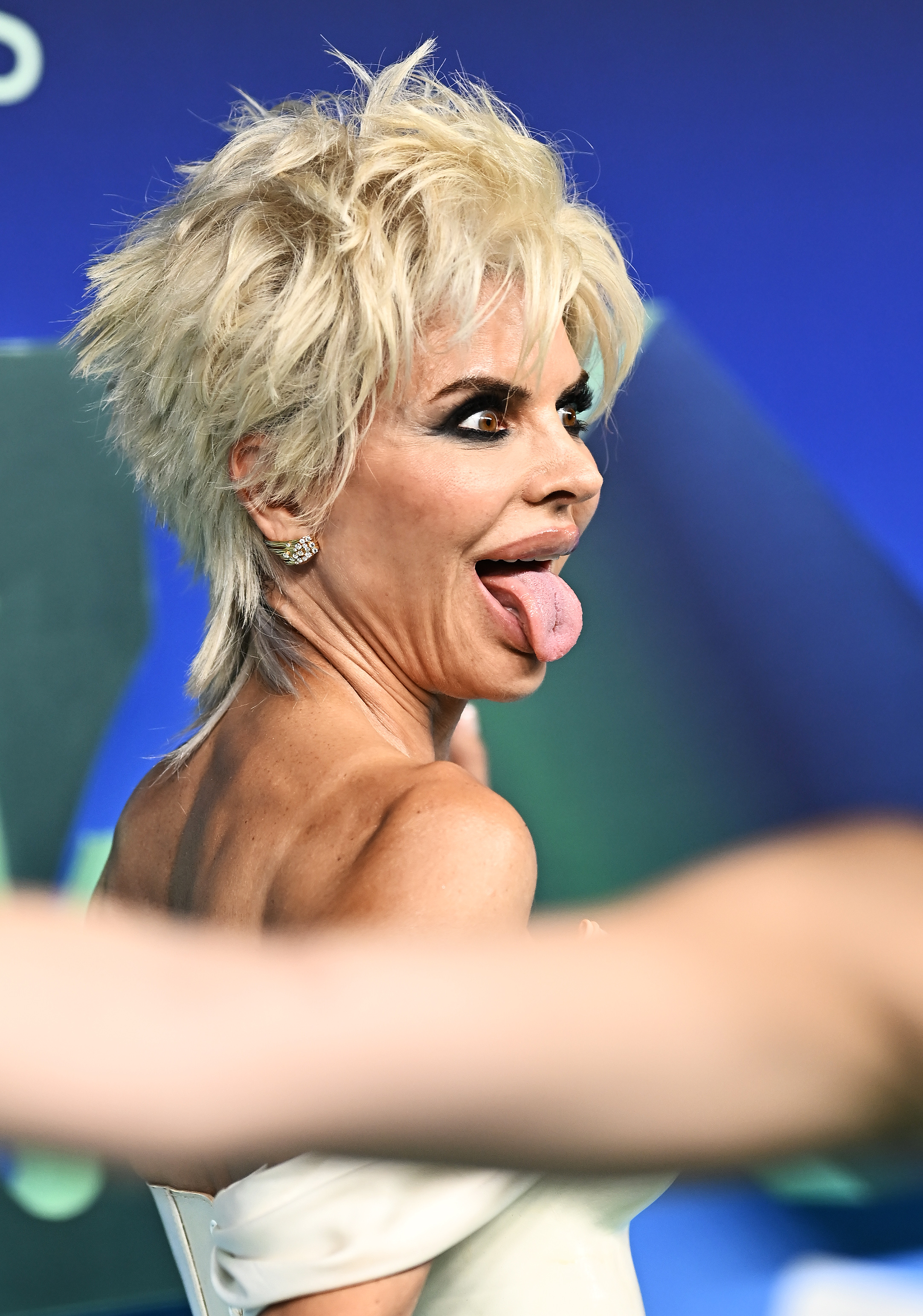 Rinna showed her playful side as she turned toward the cameras and stuck out her tongue. The close-up also offered another view of her choppy platinum layers and dramatic eye makeup. | Source: Getty Images