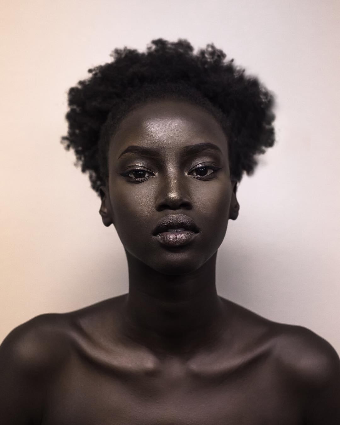 A striking portrait of Anok Yai showcasing her natural beauty in a minimalist setting, taken early in her modeling career | Source: Instagram/anokyai