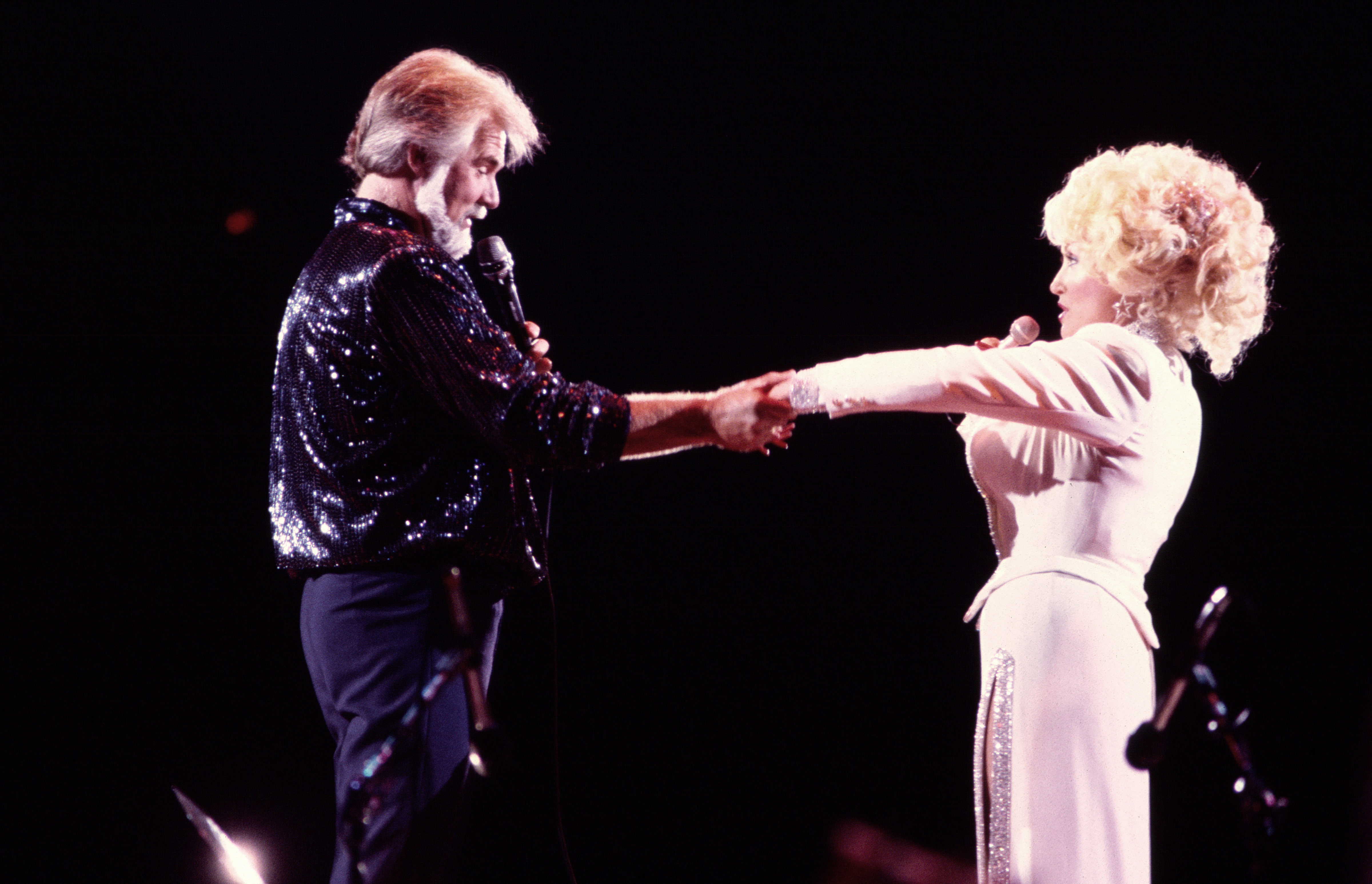 Dolly Parton and Kenny Rogers perform together onstage in 1985, years before they openly reflected on why they chose to protect their close friendship rather than pursue a romantic relationship. | Source: Getty Images