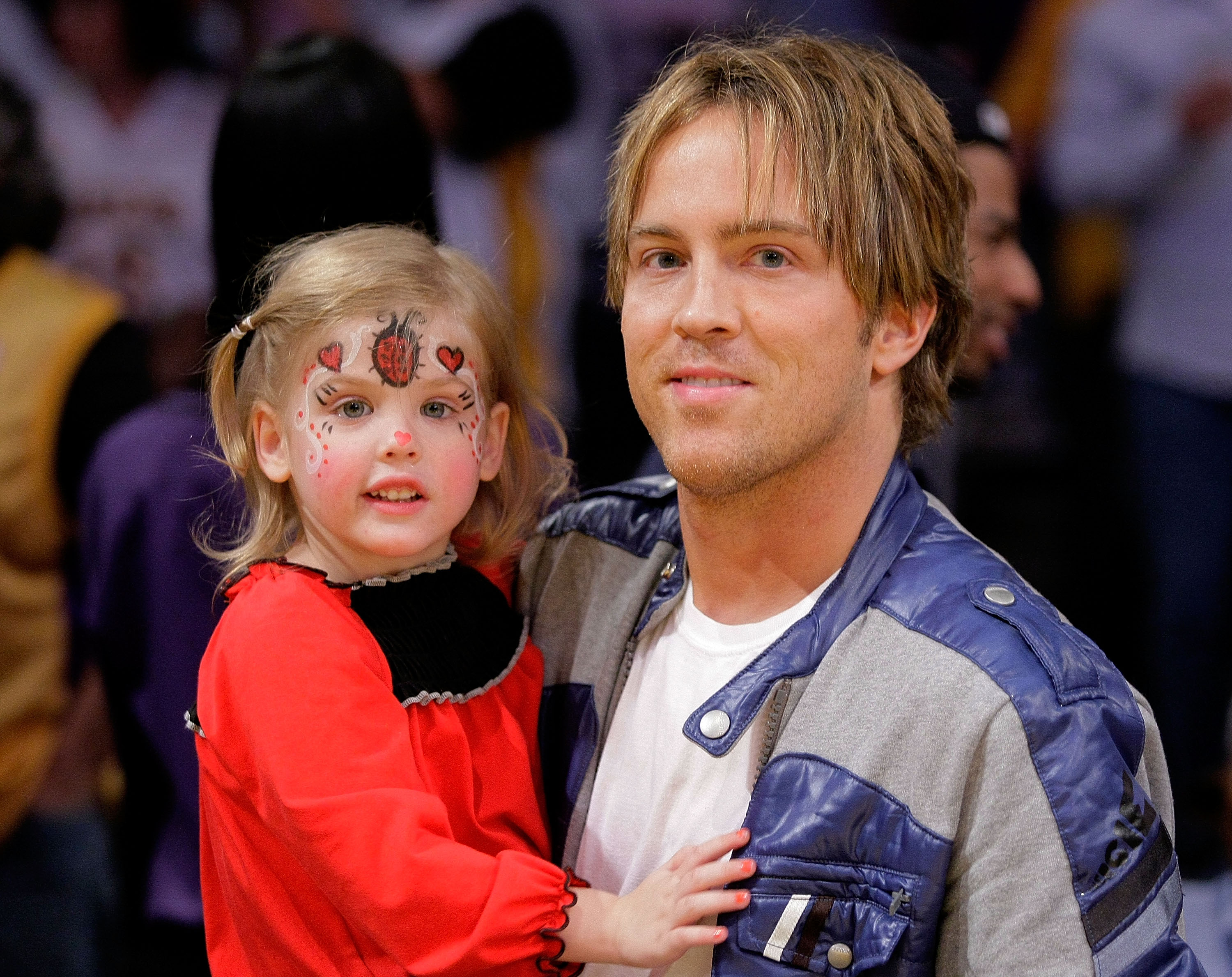 Bright ladybug face paint with little red hearts brought an extra dose of sweetness to 3-year-old Dannielynn Birkhead at the Staples Center on November 8, 2009. Cradled courtside during the Lakers game in a vibrant ruffled red long-sleeve dress, her spunky blonde pigtails and wide-eyed enthusiasm highlighted a blossoming, energetic personality.