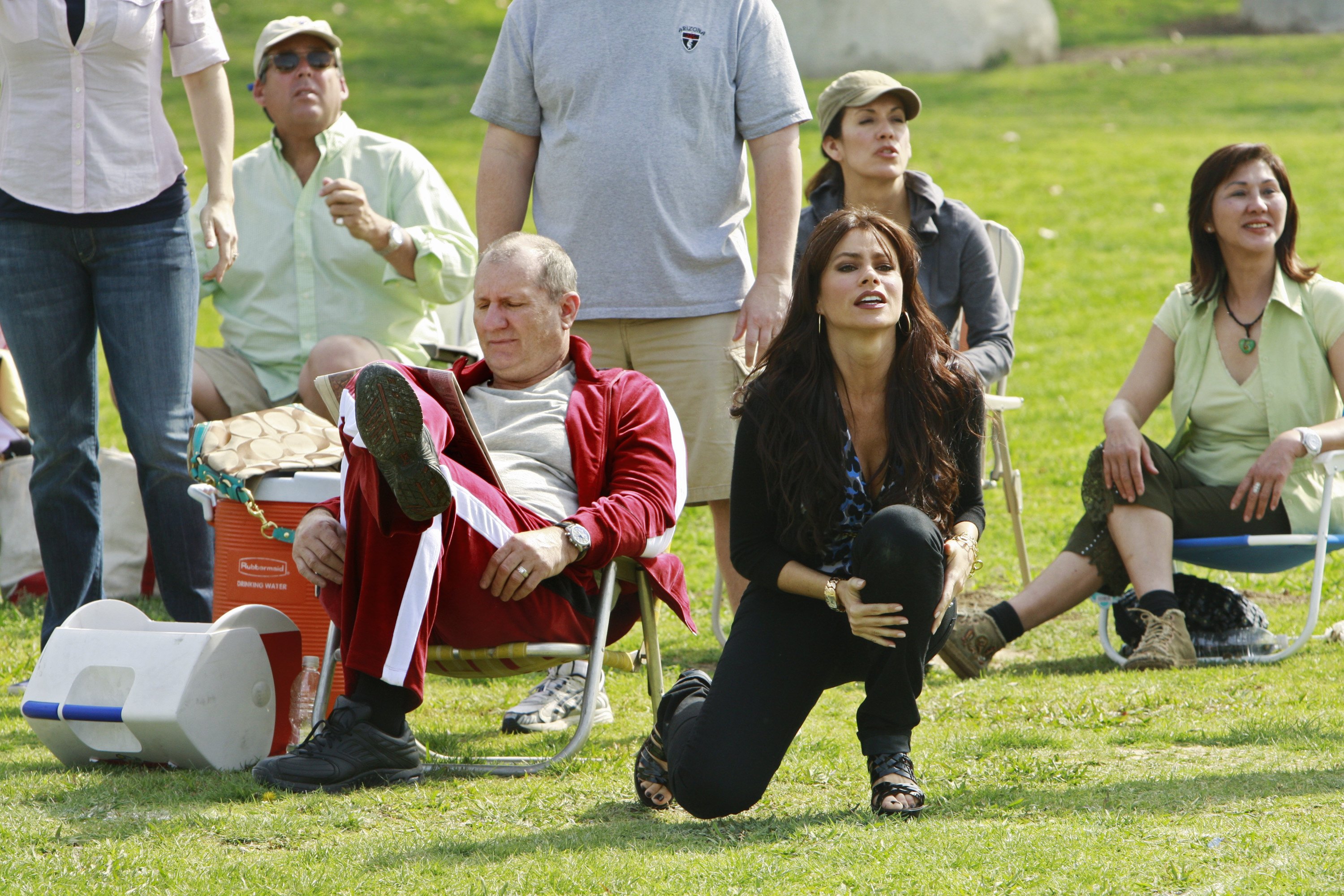 Ed O'Neill and Sofía Vergara portrayed newlyweds Jay and Gloria Pritchett in a scene from the "Pilot" episode of the ABC comedy series "Modern Family". Lounging on the sidelines of a youth soccer match, O'Neill kicked back in a lawn chair wearing a maroon-and-white tracksuit while Vergara cheered enthusiastically from the grass in a sleek black ensemble. | Source: Getty Images