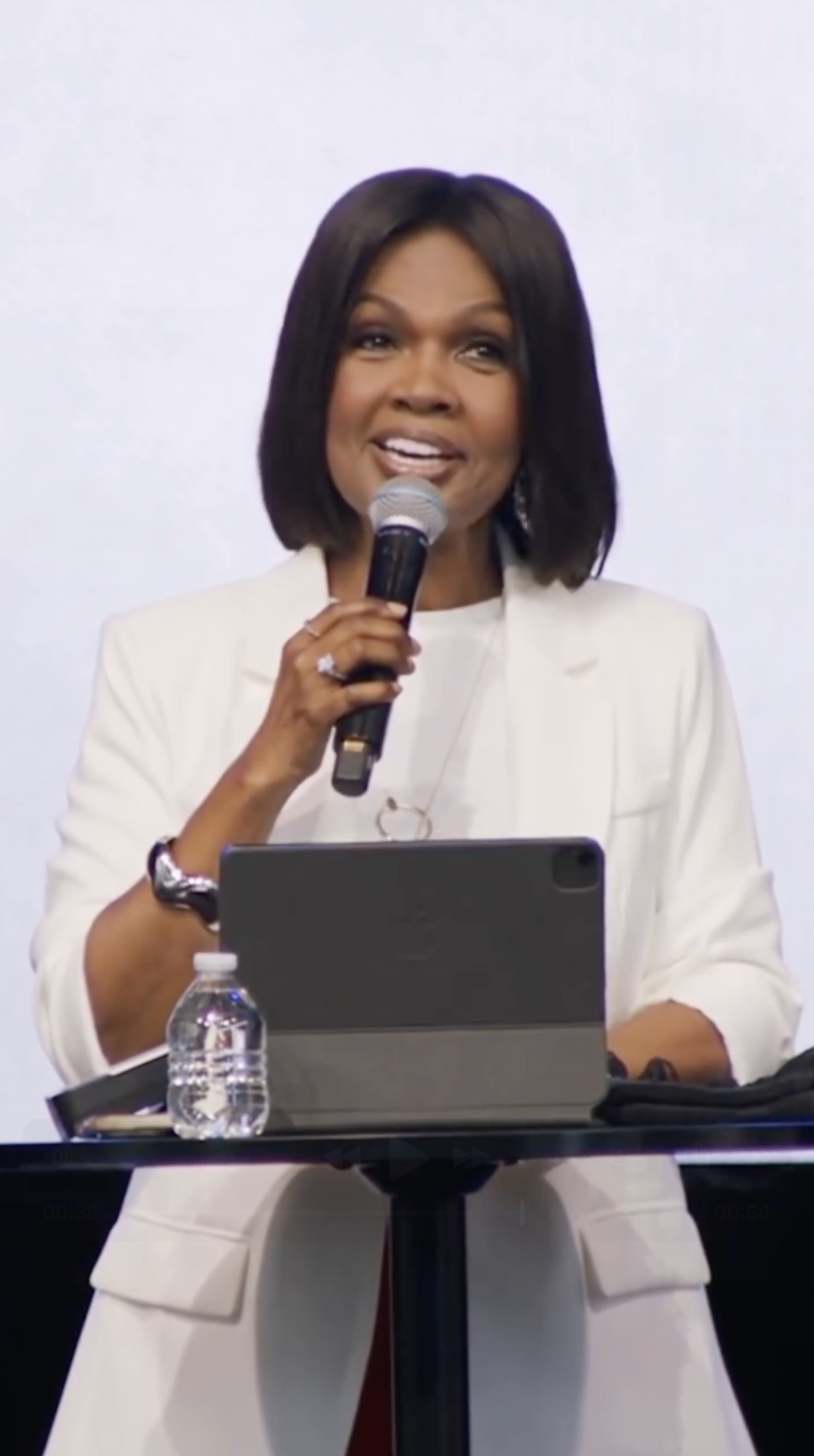 CeCe Winans speaks into a microphone while standing behind a table during a recent appearance shared on Instagram. | Source: Instagram/cecewinans