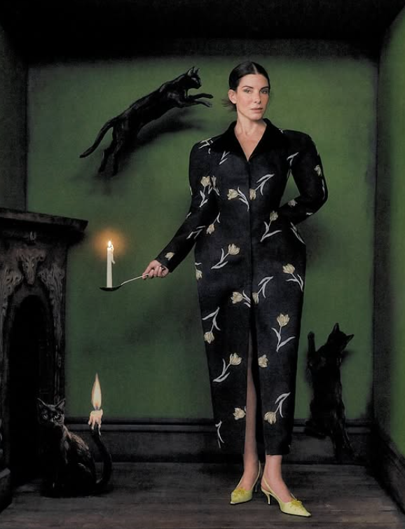 Sandra Bullock embraced a witchy mood in a floral black ensemble surrounded by candles and feline figures for her Interview Magazine cover shoot. | Source: Instagram/sandrabullock