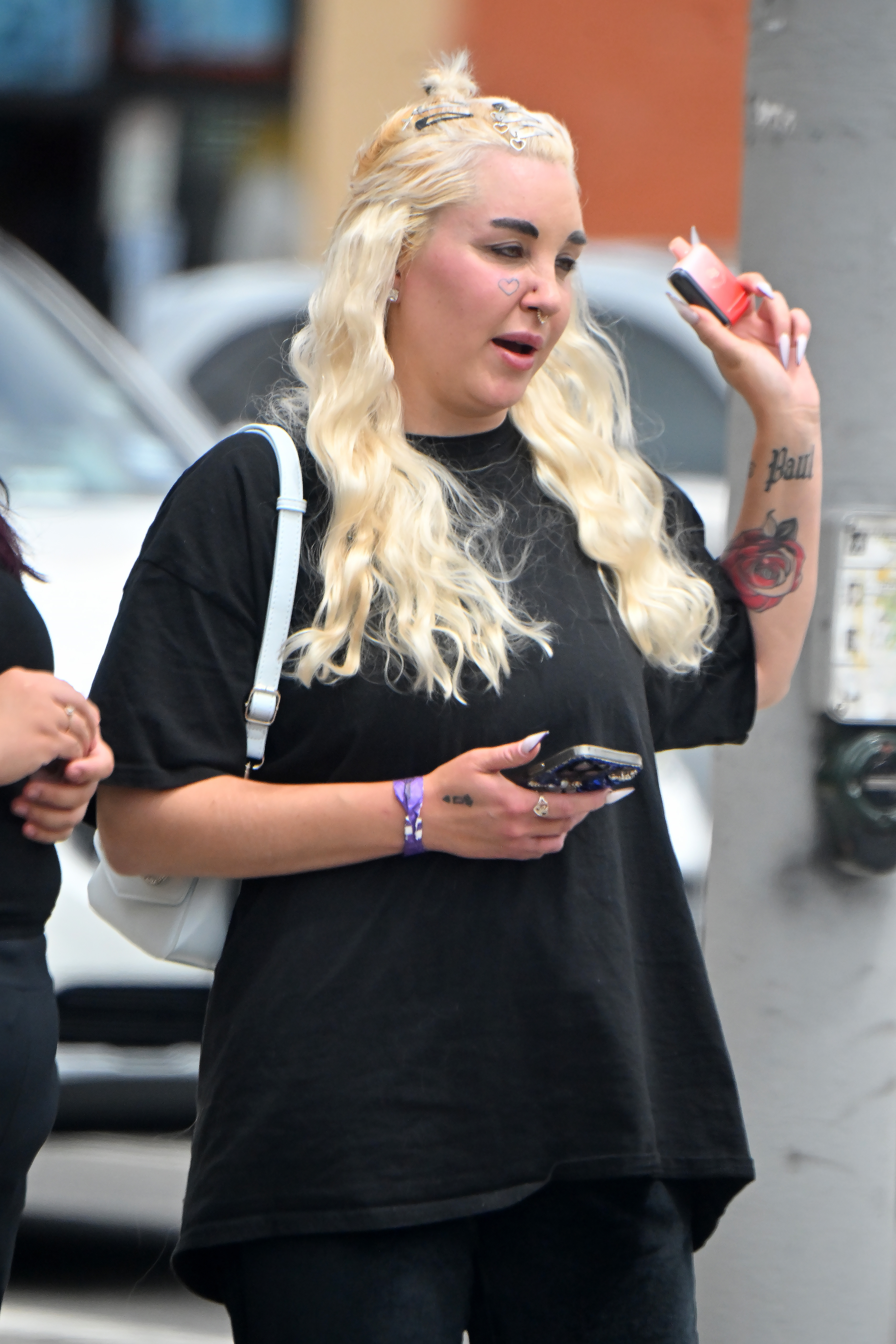 Amanda Bynes holding a small object while speaking to someone during an outing in Los Angeles on April 25, 2024 | Source: Getty Images