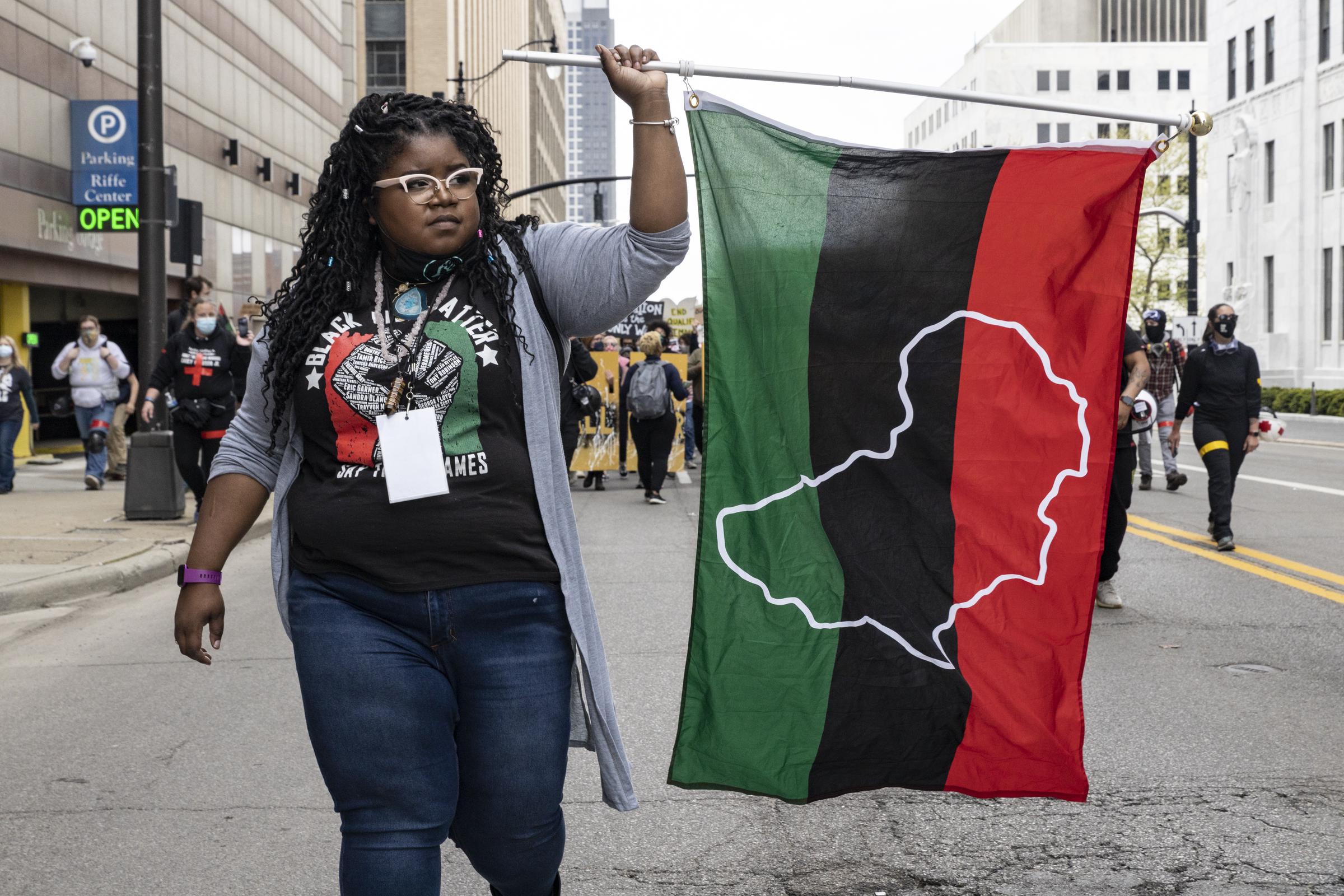 Founder of the Black Liberation Movement, Kiara Yakita, holds a Pan-African flag up during a march in Columbus, Ohio on April 17, 2021. | Source: Getty Images
