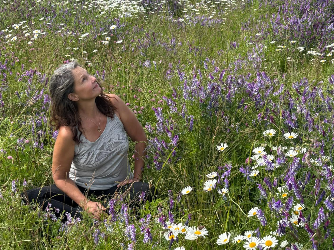 Judd's 2026 meadow portrait offers a wider view of her appearance, including her loosely styled hair and casual clothing.