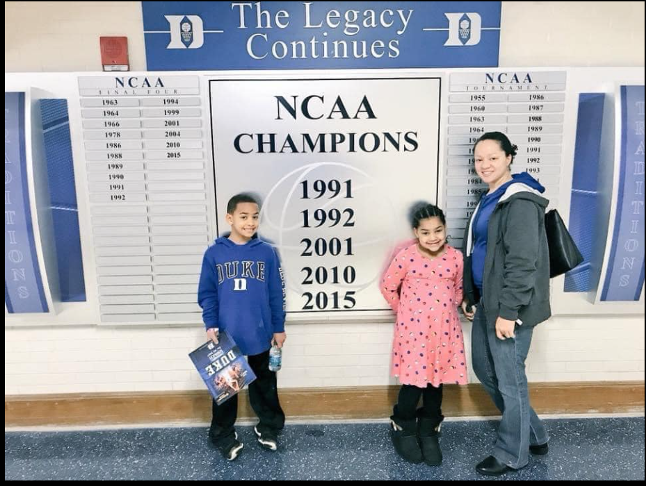 Cerina, Cameron and Carys Fairfax stand in front of a Duke NCAA Champions display. | Source: Facebook/JustinFairfax