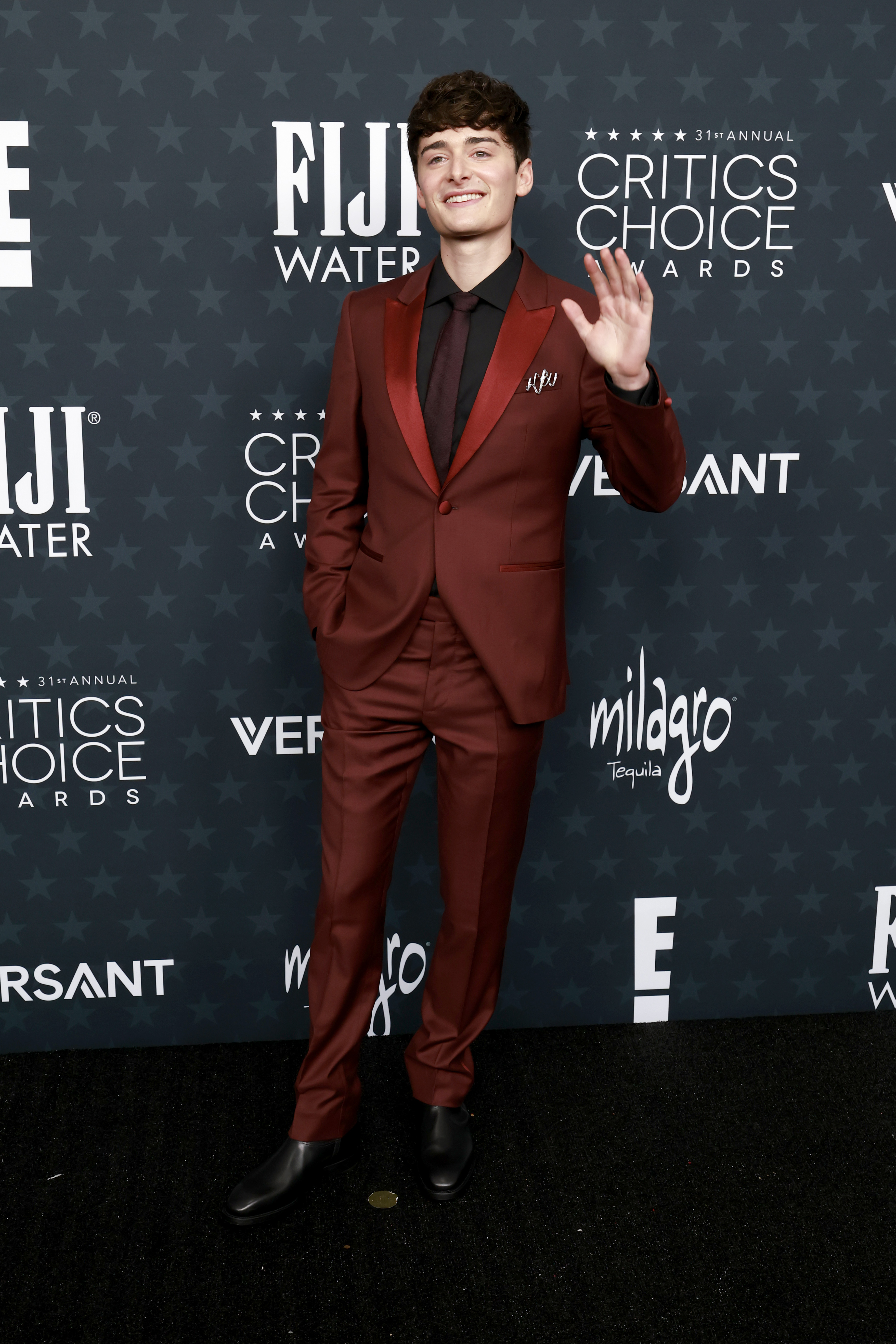 Noah Schnapp steps out in a burgundy suit with black accents, bringing youthful energy and polish to the Critics Choice red carpet | Source: Getty Images