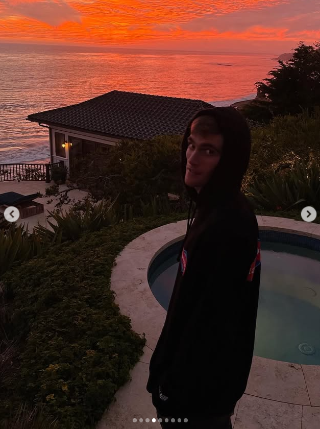 Gerber stands near a pool as a vivid sunset stretches across the ocean behind him. Wood included the image while remembering someone she described as loving, thoughtful and courageous. | Source: Instagram/lexiwood