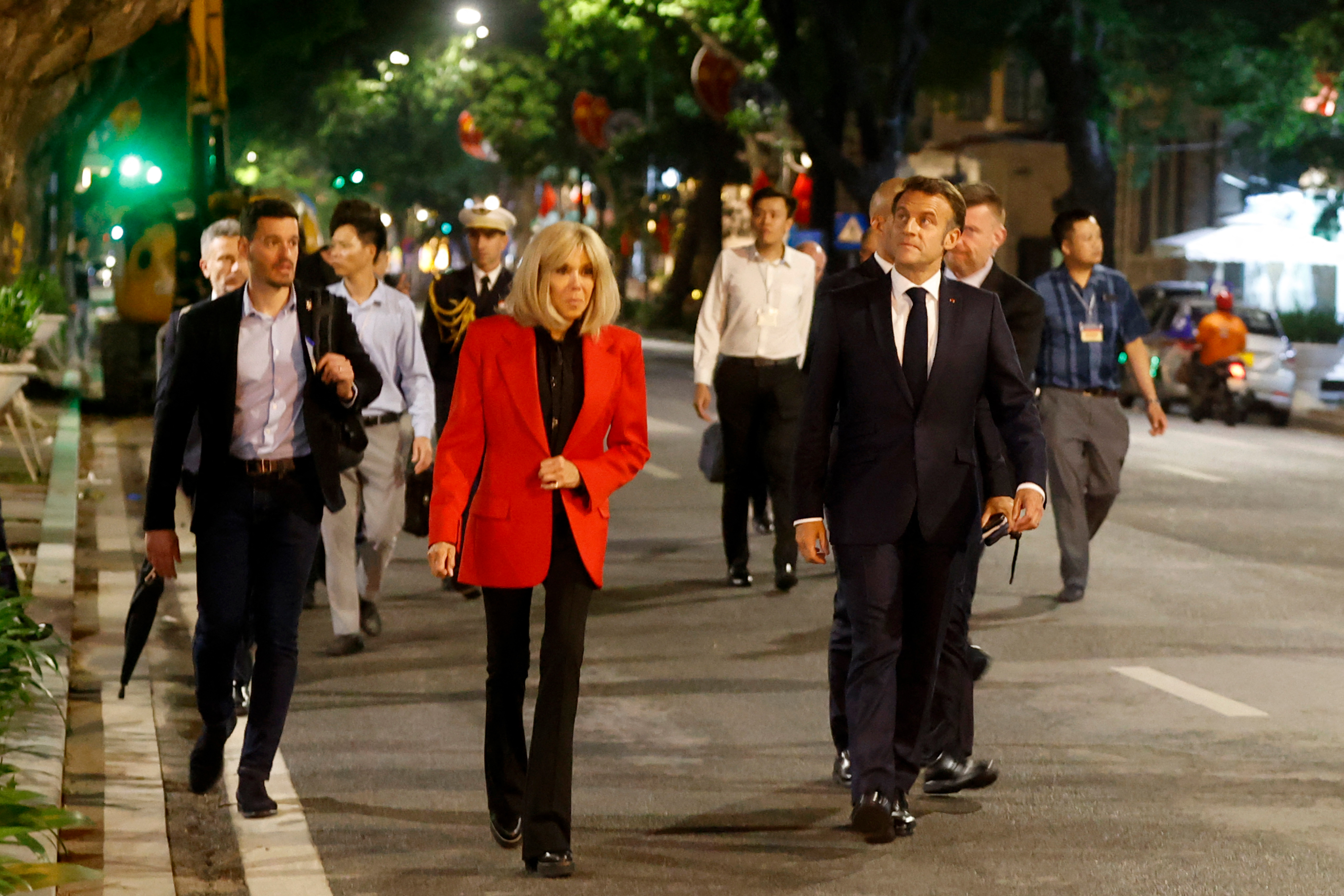 Brigitte and Emmanuel Macron walking in the street with an entourage in Hanoi, Vietnam. | Source: Getty Images