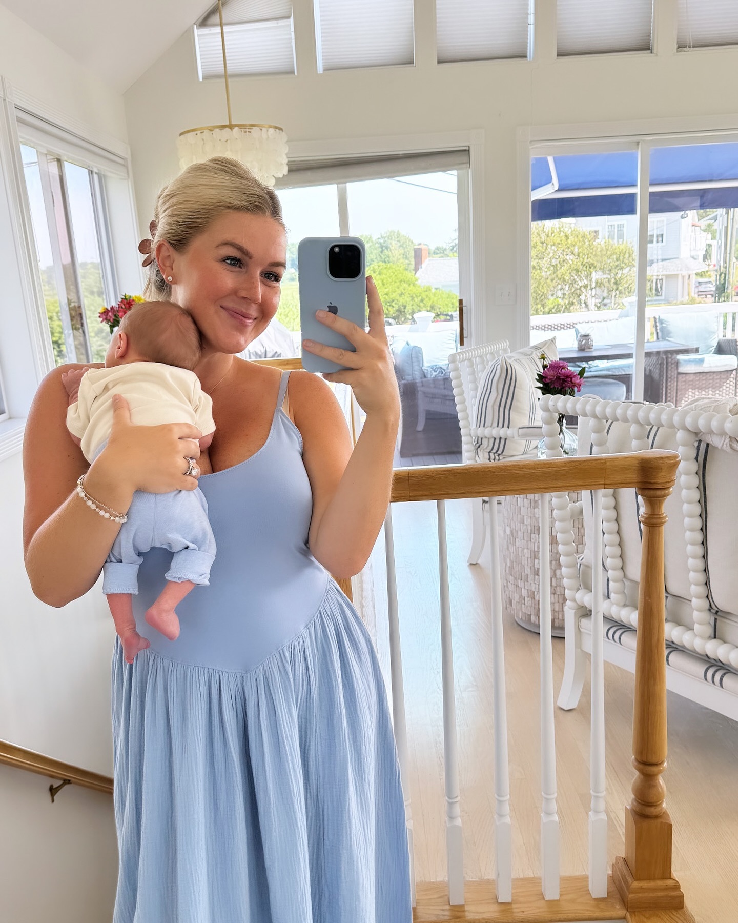 This image offers one of the clearest glimpses of the home's light, airy decorating style, with rows of white furniture and sunshine filling the room behind Leavitt. The pale-blue dress and soft neutral interiors almost echo the color palette found elsewhere in the family's nursery spaces. | Source: Instagram/karolineleavitt