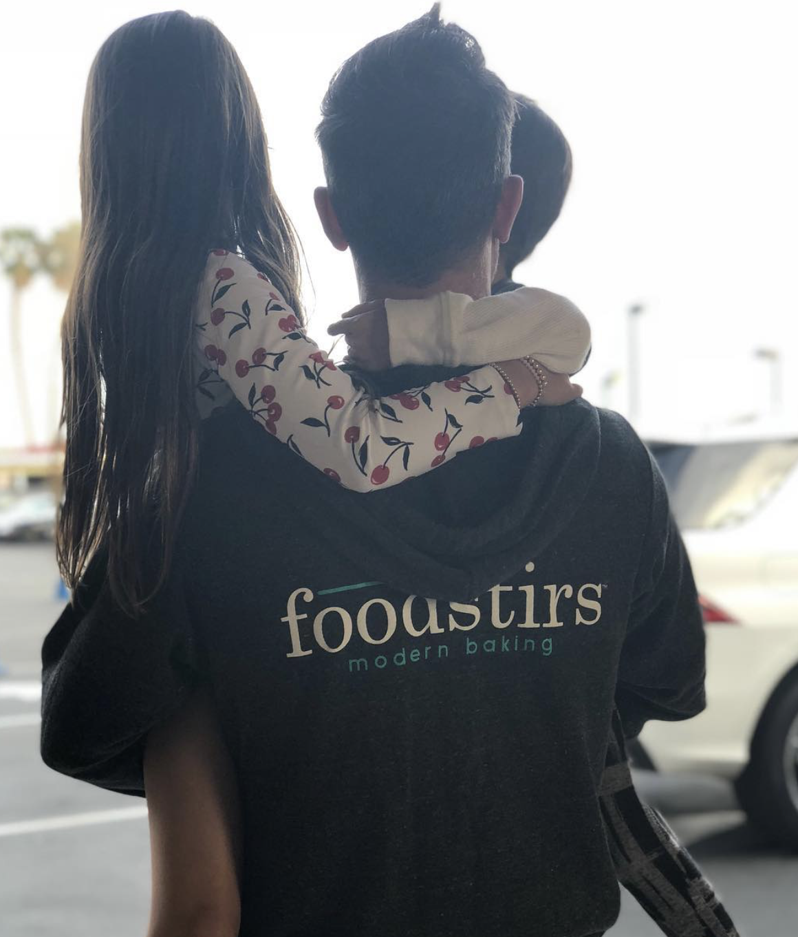 Freddie Prinze Jr. carried his young son Rocky while daughter Charlotte wrapped her arms around his shoulders. Freddie wore a Foodstirs hoodie, representing the family-focused baking brand cofounded by Sarah Michelle Gellar. | Source: Instagram/@sarahmgellar