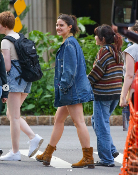Suri Cruise is captured striding down the street in a chic denim outfit that blends casual ease with standout style. Her oversized jacket, paired with cut-off shorts and suede boots, channels a modern take on Western flair. | Source: Instagram/pagesix