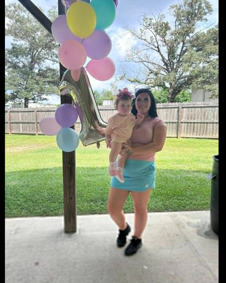 Keziah Luker stands under a covered outdoor space holding her toddler on her hip. | Source: Facebook/Keziah Luker