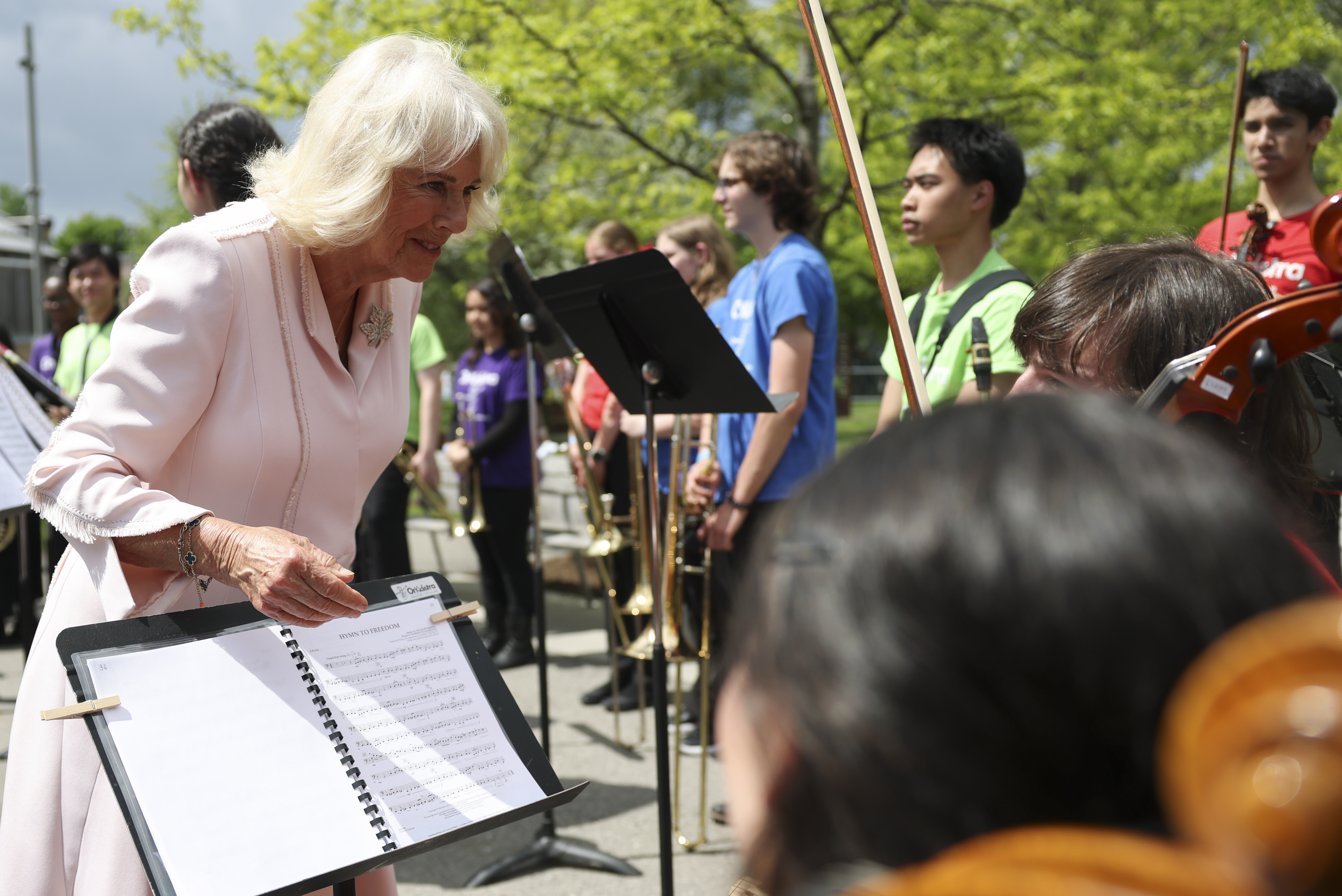 While at Lansdowne Park, Queen Camilla engages with music students, taking time to interact with their displayed work and showing genuine interest in their creative efforts.