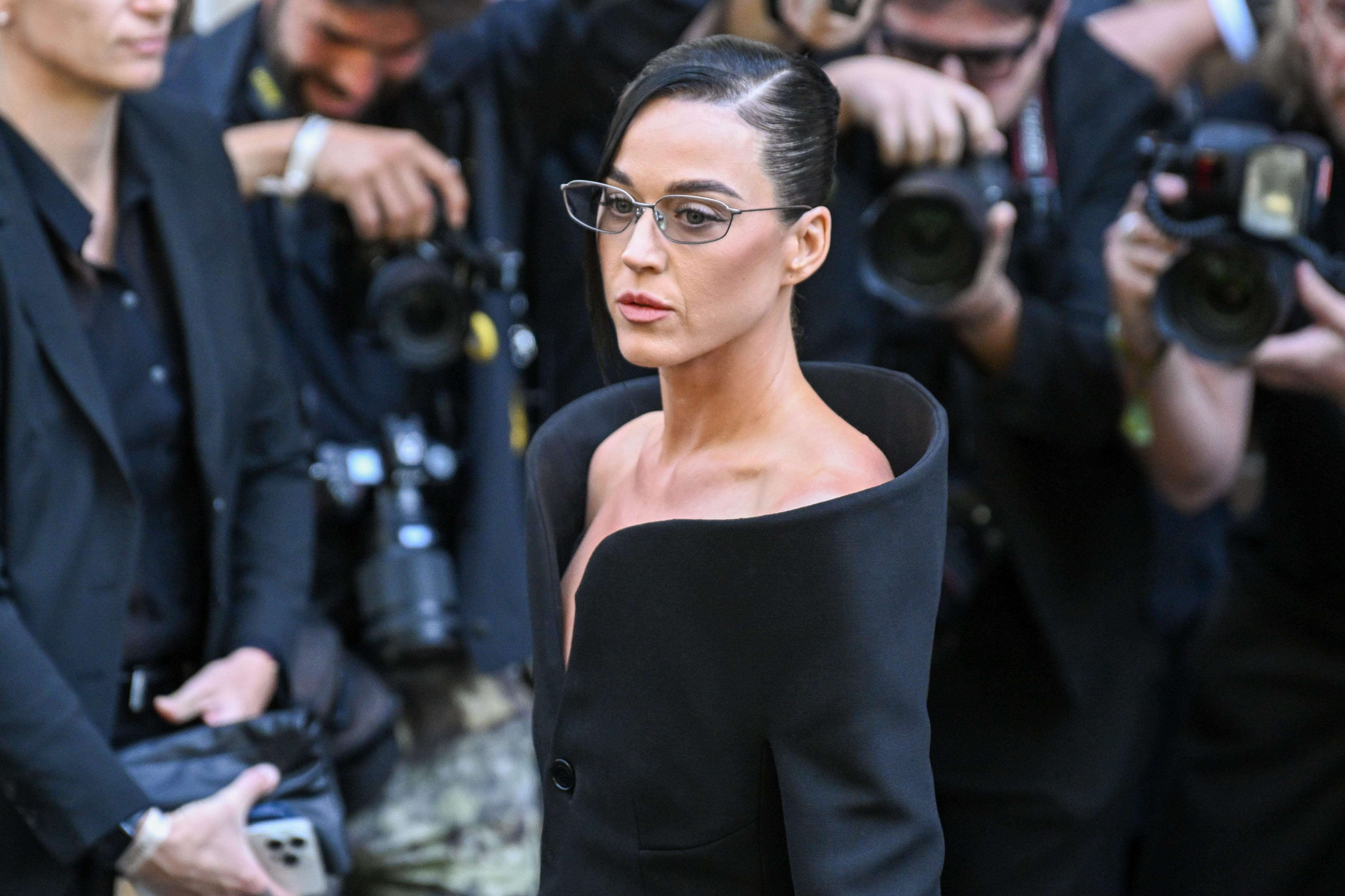 The legal battle over Perry's Montecito mansion continued even after a judge upheld the sales agreement. The singer, pictured wearing a black off-the-shoulder outfit at Paris Fashion Week on July 9, 2025, remained linked to the dispute over financial damages. | Source: Getty Images