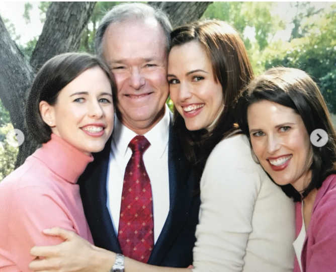 William Garner smiles as his daughters gather around him beneath a tree in a family portrait included in Jennifer Garner's Father's Day carousel. The image captures the close bond the actress and her sisters shared with their late father. | Source: Instagram/jennifer.garner