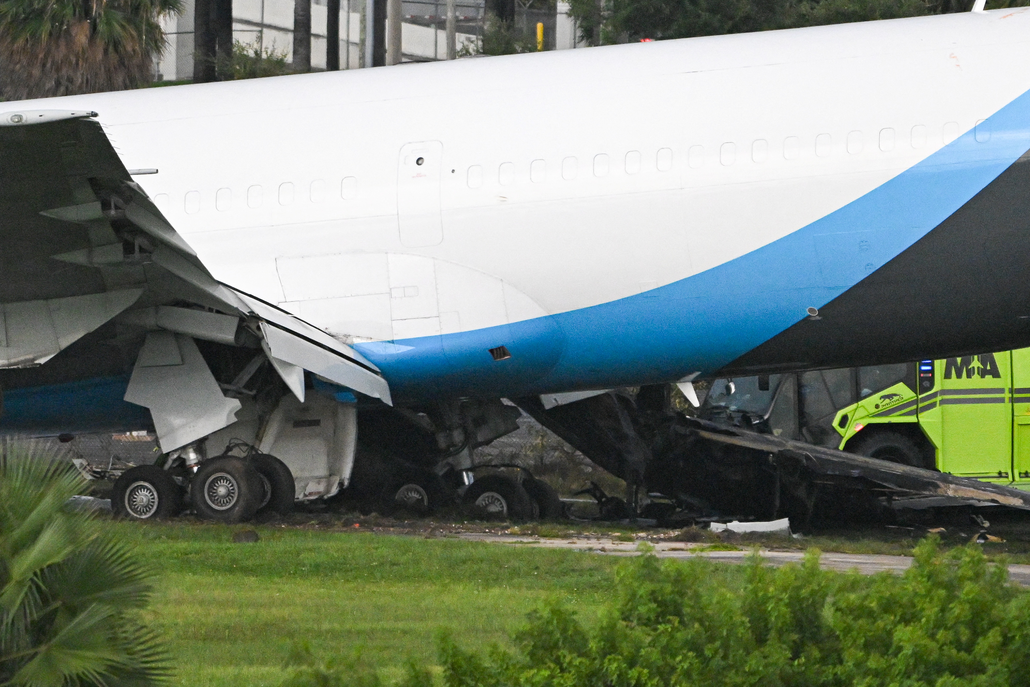 Damage is visible beneath the cargo aircraft after it traveled beyond the airport boundary. Firefighters encountered a complex engine compartment fire, while hazardous materials crews worked to mitigate a fuel leak. | Source: Getty Images
