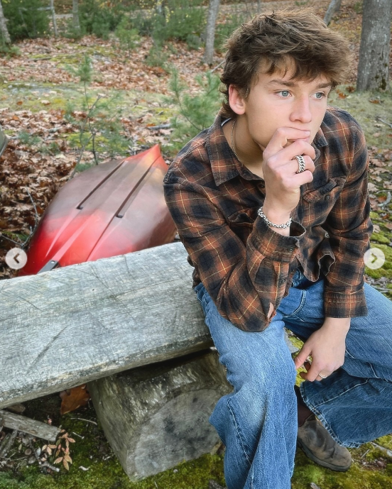 Darby Dempsey sitting on a bench with a canoe nearby, from a post dated November 26, 2025 | Source: Instagram/jilliandempsey