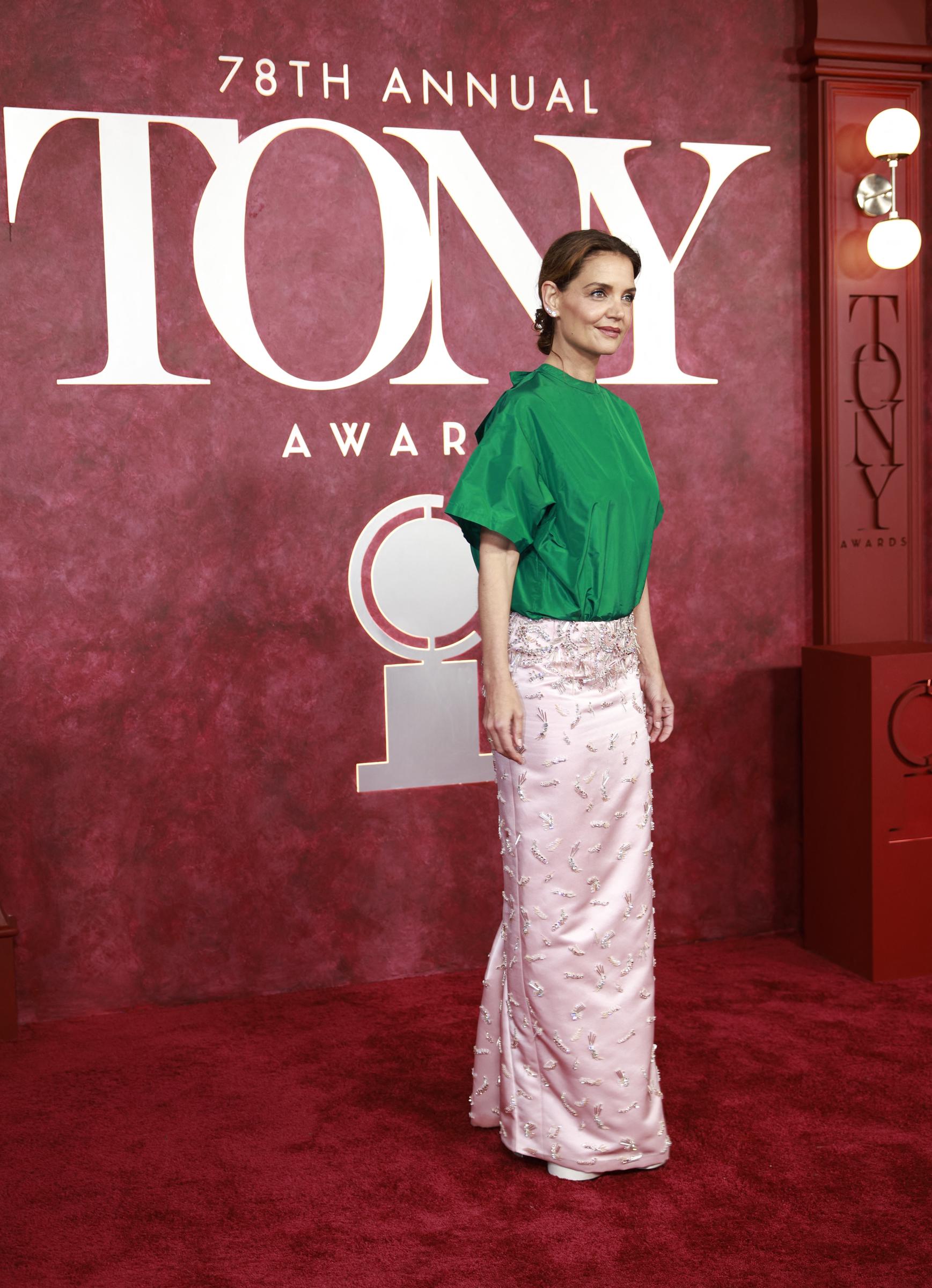 With one foot slightly forward and her posture composed, Katie Holmes commands the red carpet in her green and pink ensemble. The photo captures both elegance and boldness — mirroring the reactions her look stirred across social media.