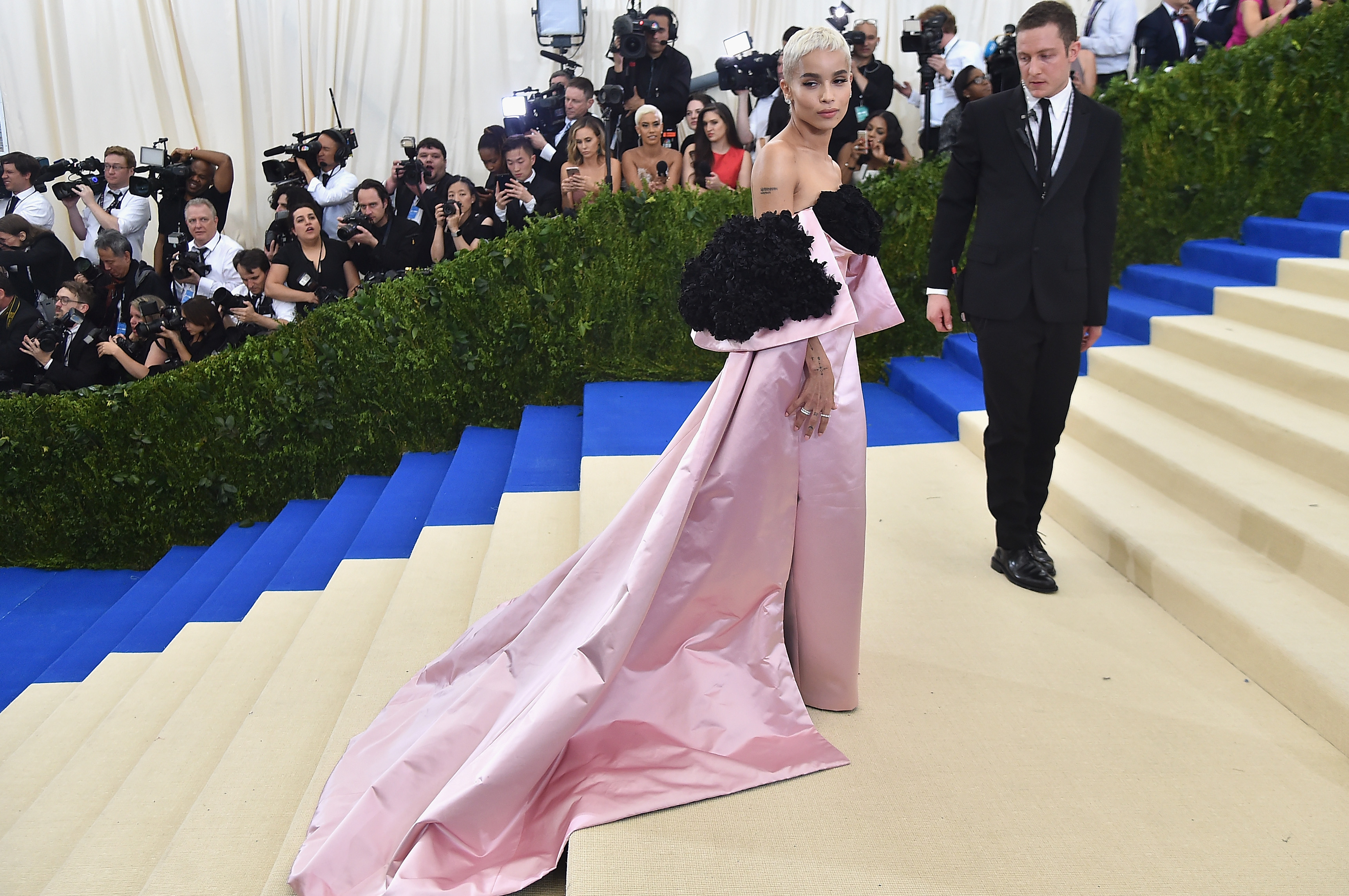 Zoë Kravitz attended the "Rei Kawakubo/Comme des Garçons: Art of the In-Between" Costume Institute Gala at the Metropolitan Museum of Art in New York City on May 1. She wore a dramatic off-the-shoulder pink gown with oversized black floral accents and a sweeping train, styled with platinum blonde hair and soft pink makeup.
