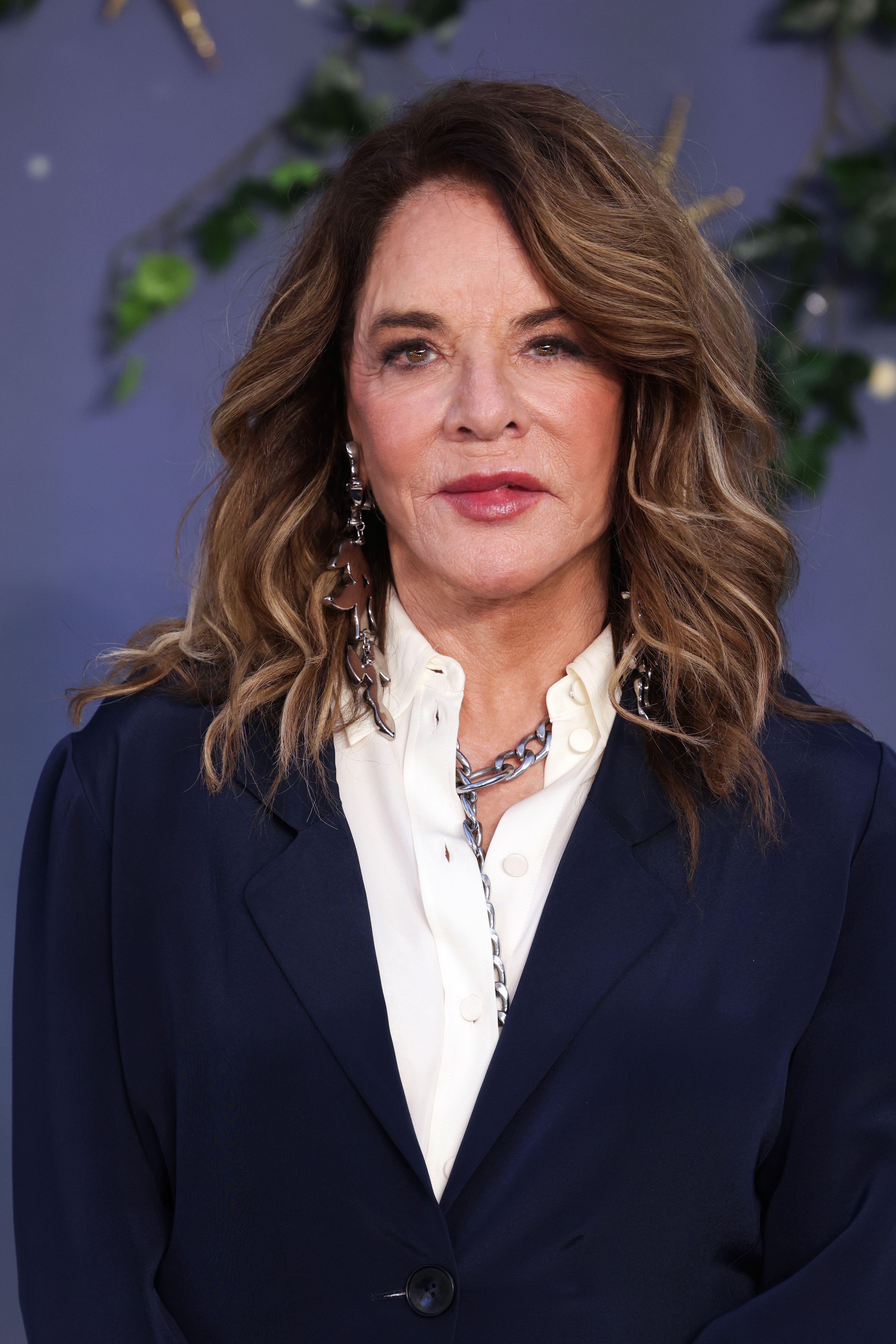 Stockard Channing gives a close-up portrait at the Practical Magic 2 European premiere at London's Odeon Luxe Leicester Square on August 26, 2026. With her softly waved highlighted hair, navy tailoring, ivory blouse and dramatic silver earrings, the actress makes her rare return to the red carpet look effortlessly polished. | Source: Getty Images