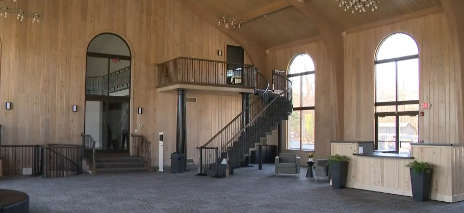 The mansion's towering wood-paneled hall appeared renewed after the church's extensive renovations, with fresh carpeting covering the floor and seating arranged beneath its arched windows. A staircase and upper balcony remained as recognizable features from the property's earlier design, while understated furnishings gave the cavernous room a new function within the religious campus that replaced Mike Tyson's former private residence. | Source: YouTube/WKYC Channel 3