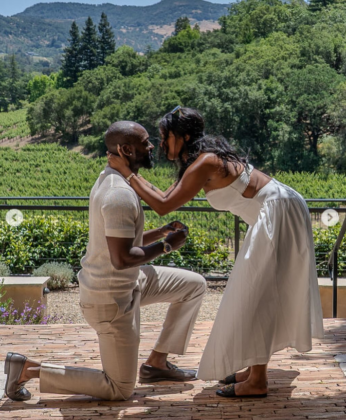 Javicia Leslie’s groom, Nana-Yaw Asamoah, is down on one knee on a sunlit terrace overlooking lush vineyards and rolling hills. | Source: Instagram/javicia