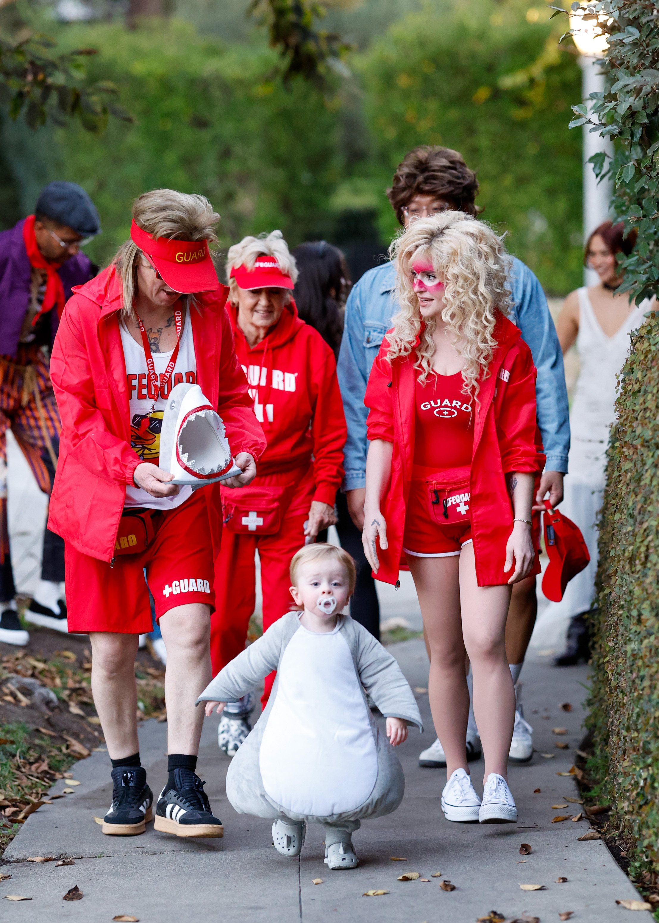 Kelly Osbourne and Sid Wilson dressed as lifeguards while their young son, Sidney, stole the show in an adorable shark costume during a family Halloween outing. | Source: Getty Images